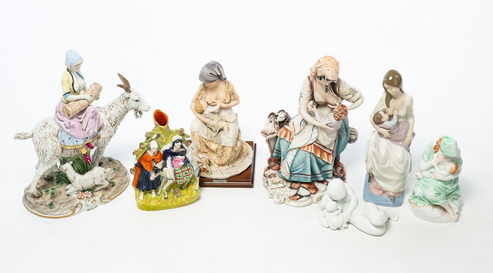 SEVEN EUROPEAN AND ENGLISH PORCELAIN FIGURINES OF NURSING MOTHERS, INCL. HEREND.: SEVEN EUROPEAN AND ENGLISH PORCELAIN FIGURINES OF NURSING MOTHERS, INCL. HEREND. 20th Century. Comprising a Herend mother dressed in green with her child, marked; a Dresden mother on a goat, marked;