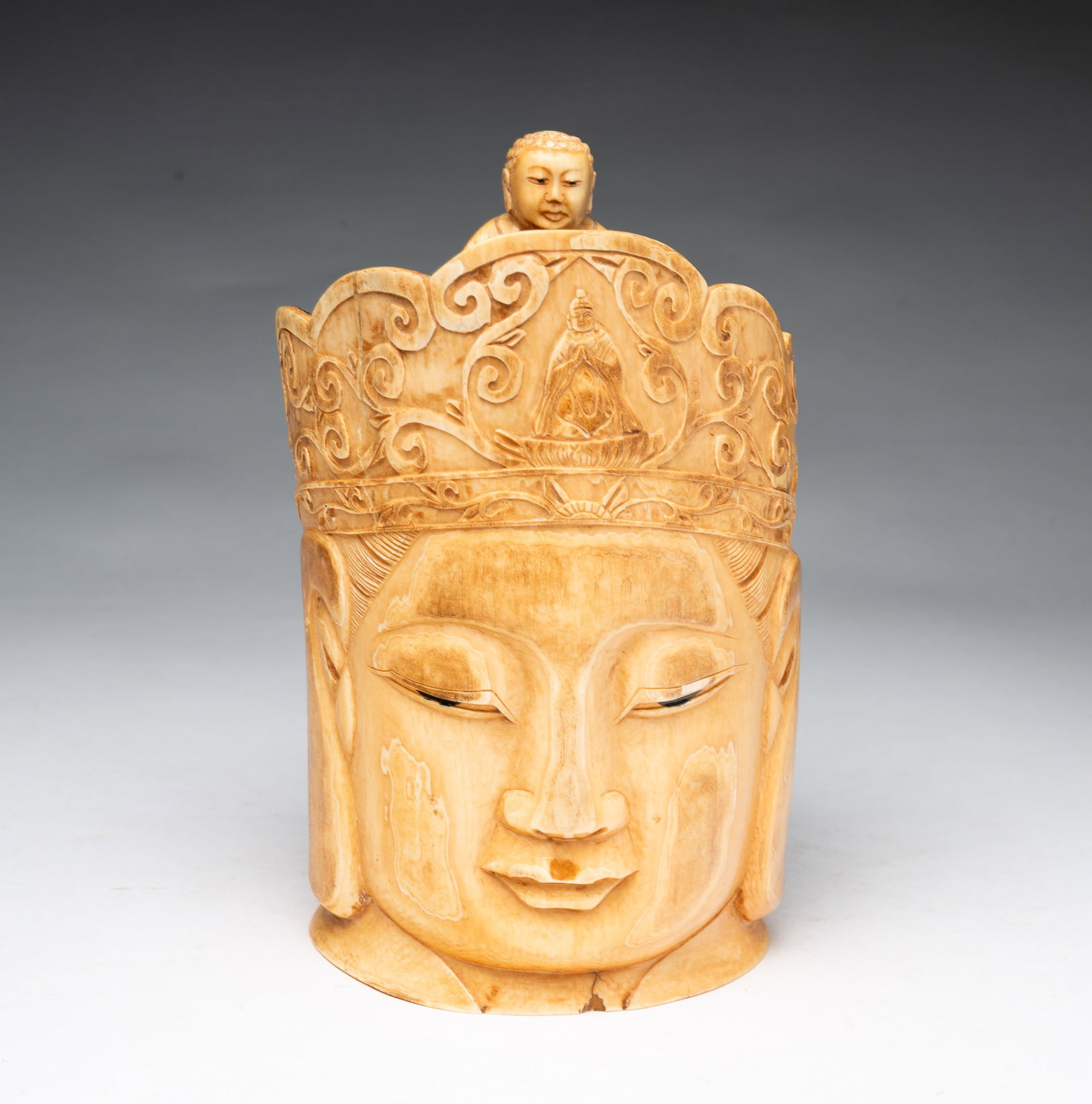 CHINESE CARVED BUDDHIST DEITY FIGURE.: CHINESE CARVED BUDDHIST DEITY FIGURE. China, 19th Century. Of natural material, the carved head of Guanyin with relief-carved details and a diminutive Buddha figure at the top of the head. Signed to