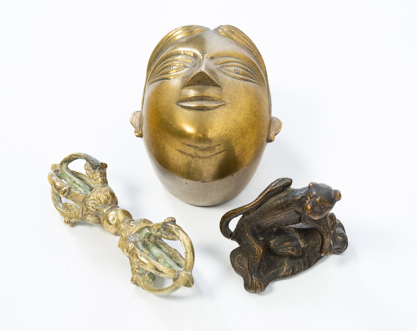 THREE SOUTHEAST ASIAN ITEMS.: THREE SOUTHEAST ASIAN ITEMS. Late 19th or Early 20th Century. Including a Chinese bronze scroll weight in the form of a mountain cat, a Tibetan vajra, 4.25"w., and a lidded box depicting Gauri,