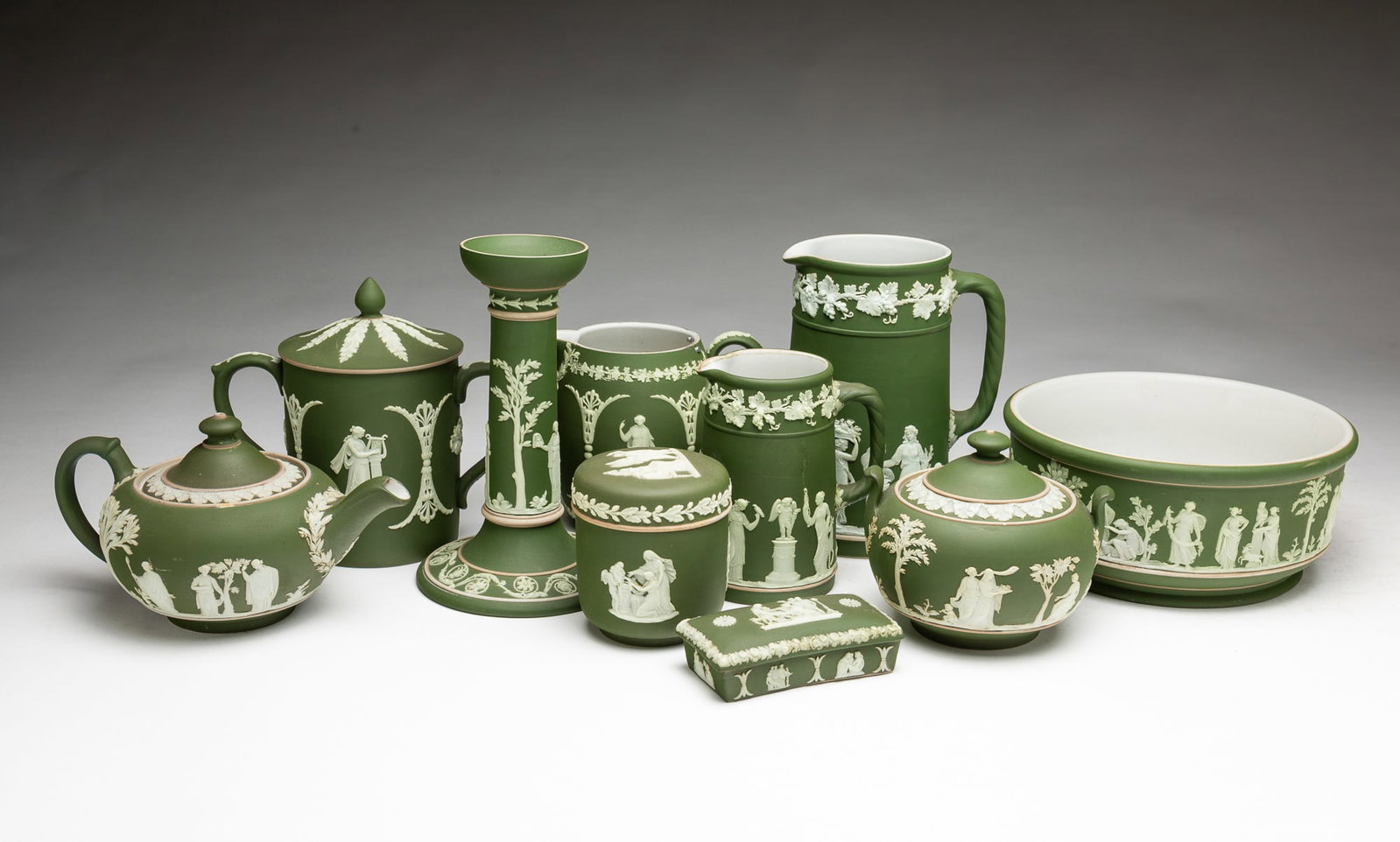 GROUP OF WEDGWOOD OLIVE GREEN DIP JASPERWARE ITEMS.: GROUP OF WEDGWOOD OLIVE GREEN DIP JASPERWARE ITEMS. England, Late 19th or Early 20th Centuries. Ten items with impressed WEDGWOOD ENGLAND mark. Two pitchers with canted sides, two lidded dresser