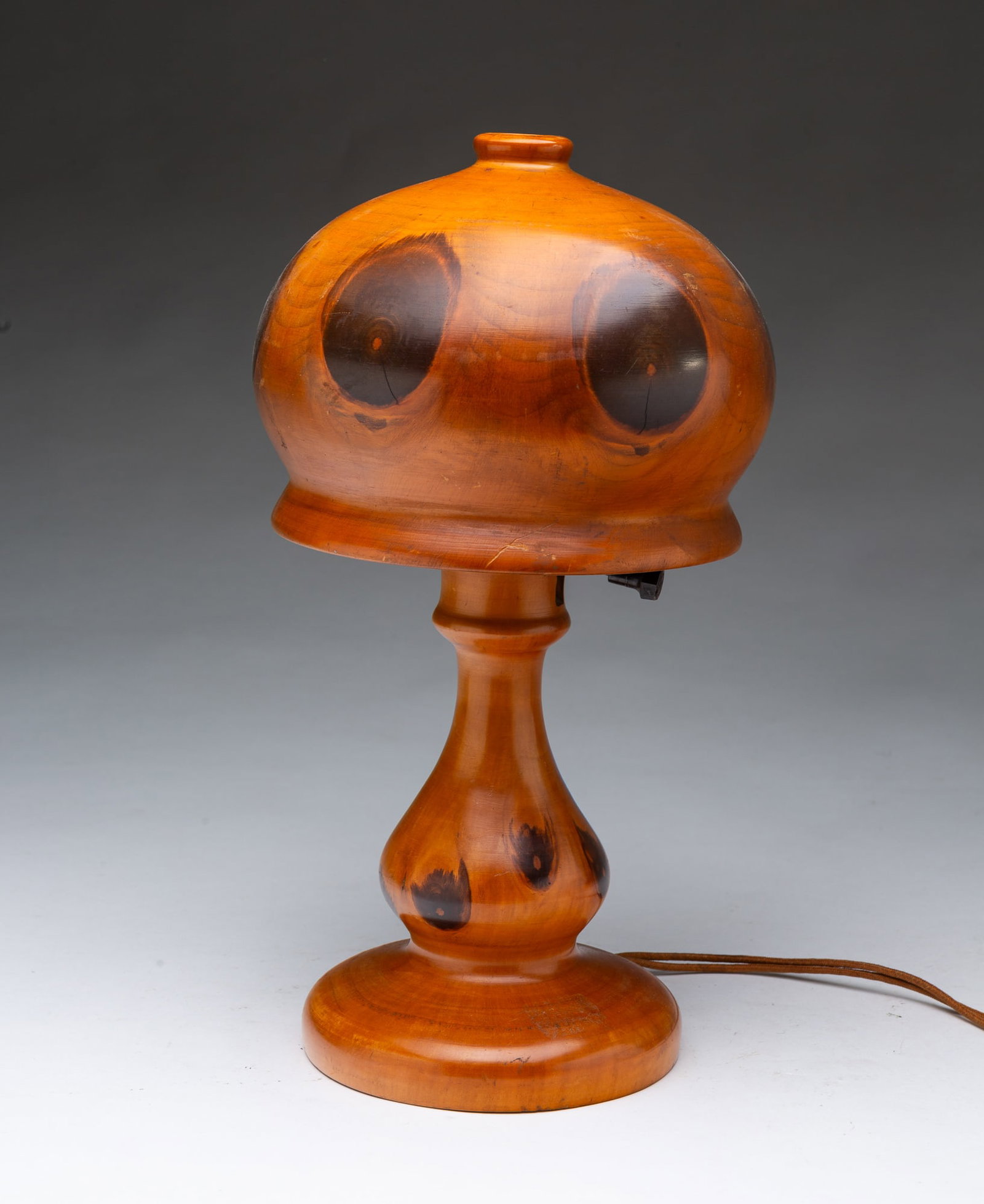 BRAZILIAN BUTTERFLY WOOD TABLE LAMP.: BRAZILIAN BUTTERFLY WOOD TABLE LAMP. 20th Century. Turned wood mushroom-form shade with large knots, turned baluster-form base with large knots and circular foot, illegible labels on underside.