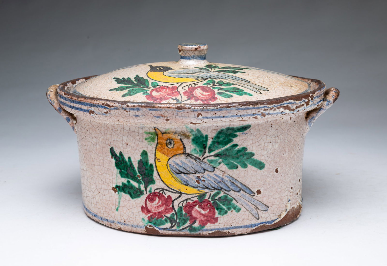 FRENCH FAIENCE-STYLE TWO-HANDLED TERRINE WITH HAND-PAINTED BIRD DECORATION.: FRENCH FAIENCE-STYLE TWO-HANDLED TERRINE WITH HAND-PAINTED BIRD DECORATION. France, Late 19th or Early 20th Century. Of oval form having a lid with final and two lug handles, decorate with birds,