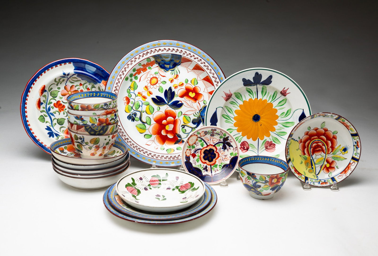 GROUP OF SOFT PASTE PORCELAIN.: GROUP OF SOFT PASTE PORCELAIN. England, 19th Century. Comprised plates, saucers, and handleless cups. In floral patterns, strawberry patterns, and Gaudy Dutch decoration. Largest, 10"d. Provenance: