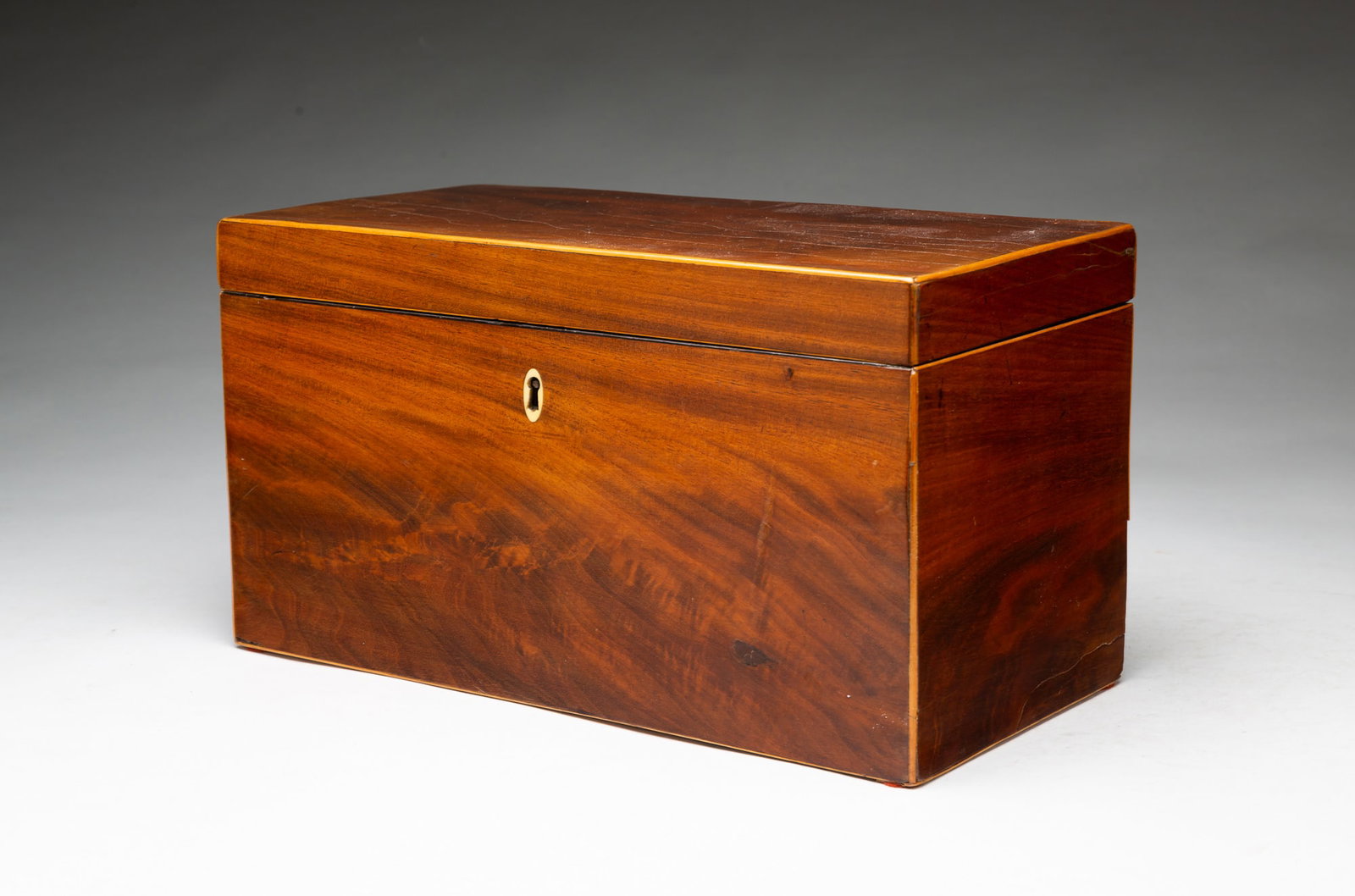 MAHOGANY VENEERED TEA CADDY.: MAHOGANY VENEERED TEA CADDY. English, Mid-19th Century. Rectangular form, opens to a large, single compartment fitted with three hinge lid boxes. 7.25"h. 13"w. 6.5"d. Provenance: From the Lifetime