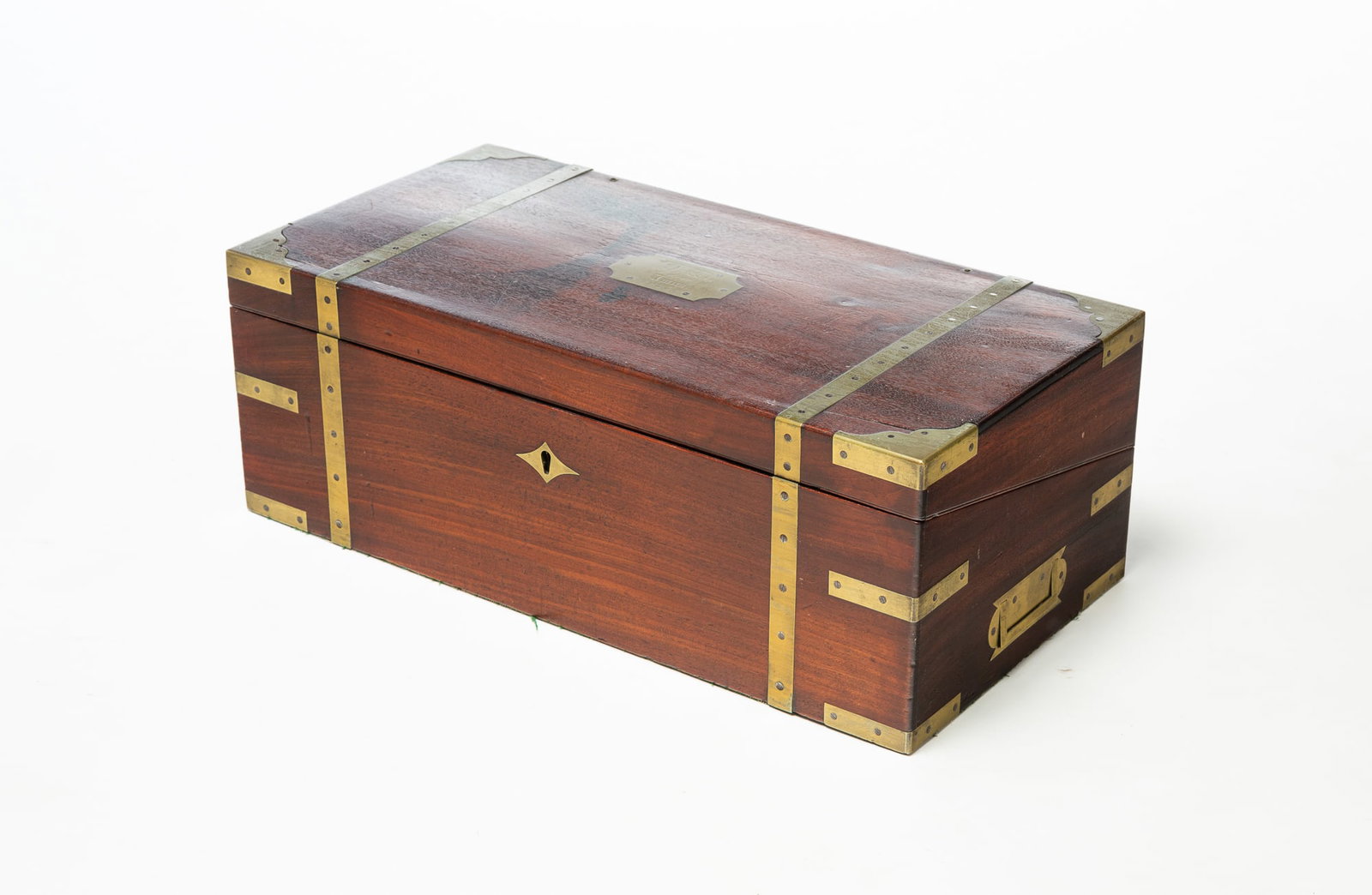 REGENCY MAHOGANY CAMPAIGN LAP DESK WITH BRASS MOUNTING.: REGENCY MAHOGANY CAMPAIGN LAP DESK WITH BRASS MOUNTING. European, 19th Century. Mahogany. Brass-mounted corners and strapping, recessed hardware, diamond-shaped escutcheon, and brass plaque on top