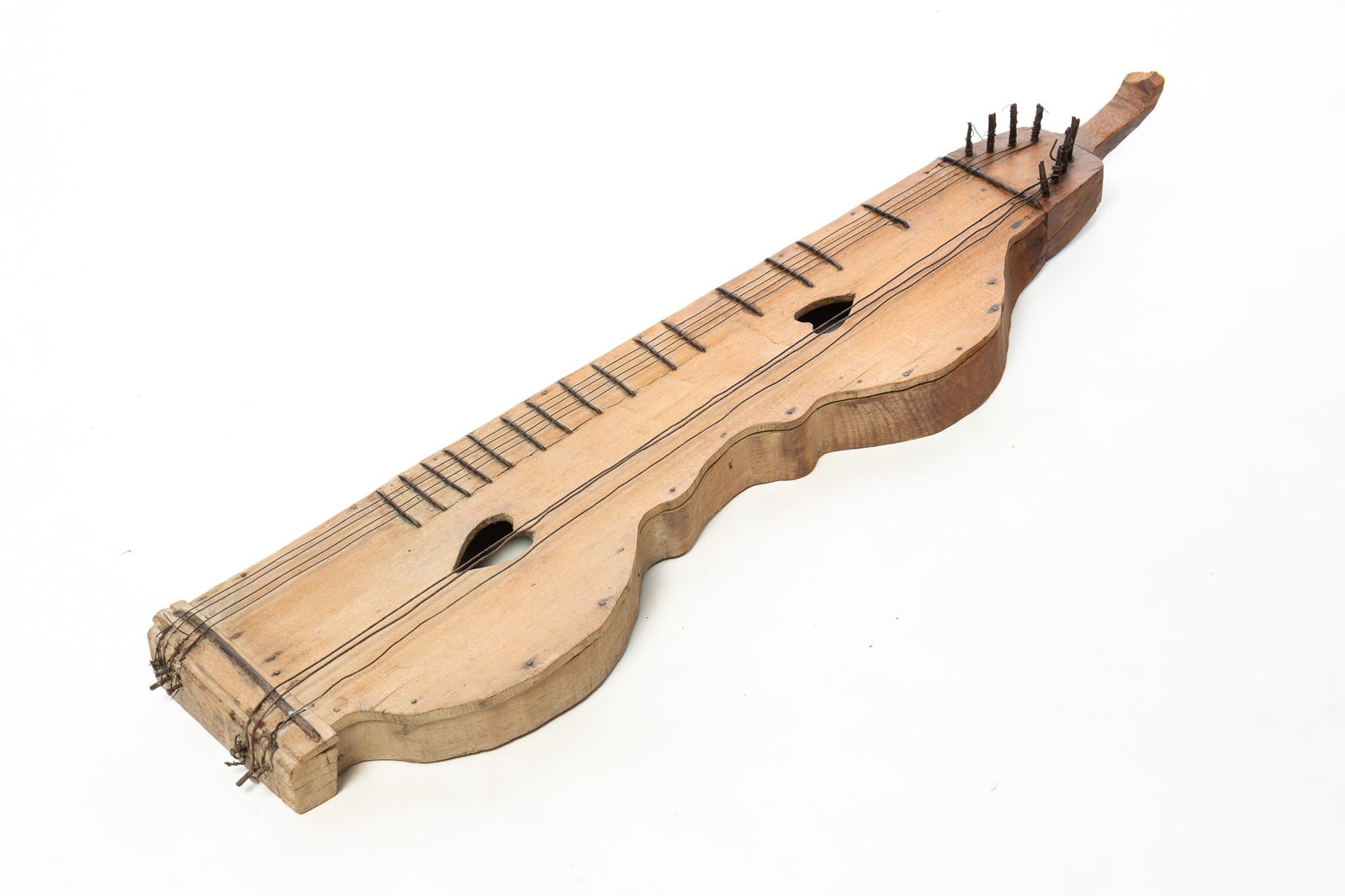 DULCIMER WITH HEART CUTOUTS.: DULCIMER WITH HEART CUTOUTS. American, 20th Century. Pine. Shaped instrument with two heart-shaped cutouts, metal frets and pegs, and seven out of eight strings. 35"h. 8"w. 4"d.