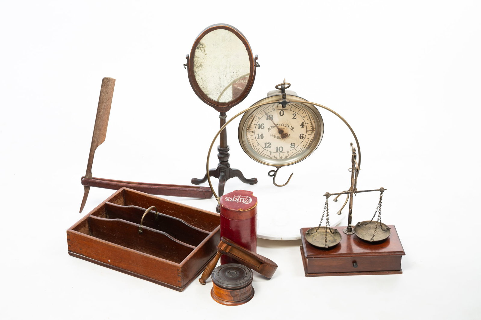 GROUPING OF HOUSEHOLD ACCESSORIES.: GROUPING OF HOUSEHOLD ACCESSORIES. American, Late 19th and early 20th Century. a Bernard Gloekler hanging deli scale, a treenware lidded box with incised banding, a cutlery tray with a brass handle, a