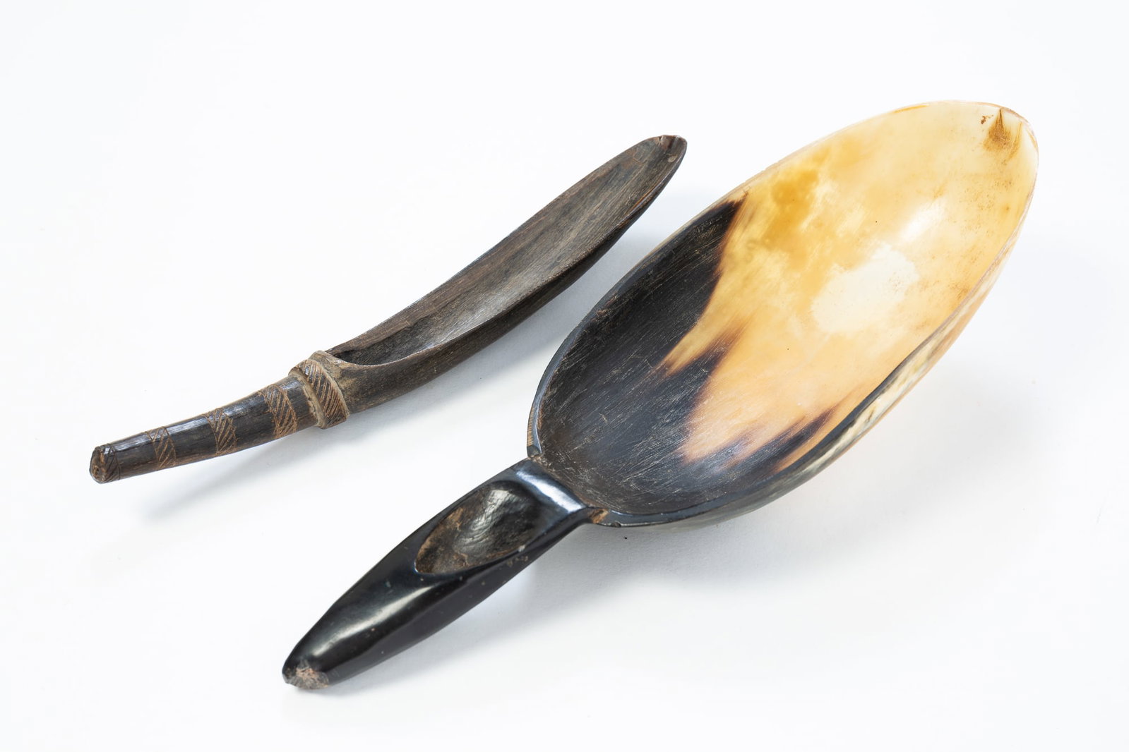 NATIVE AMERICAN CARVED BUFFALO HORN SCOOP AND CARVED HORN SPOON.: NATIVE AMERICAN CARVED BUFFALO HORN SCOOP AND CARVED HORN SPOON. 19th Century. Large buffalo horn scoop with divoted handle. 11.5"l. Elongated horn spoon with incised bands on handle. 9"l.