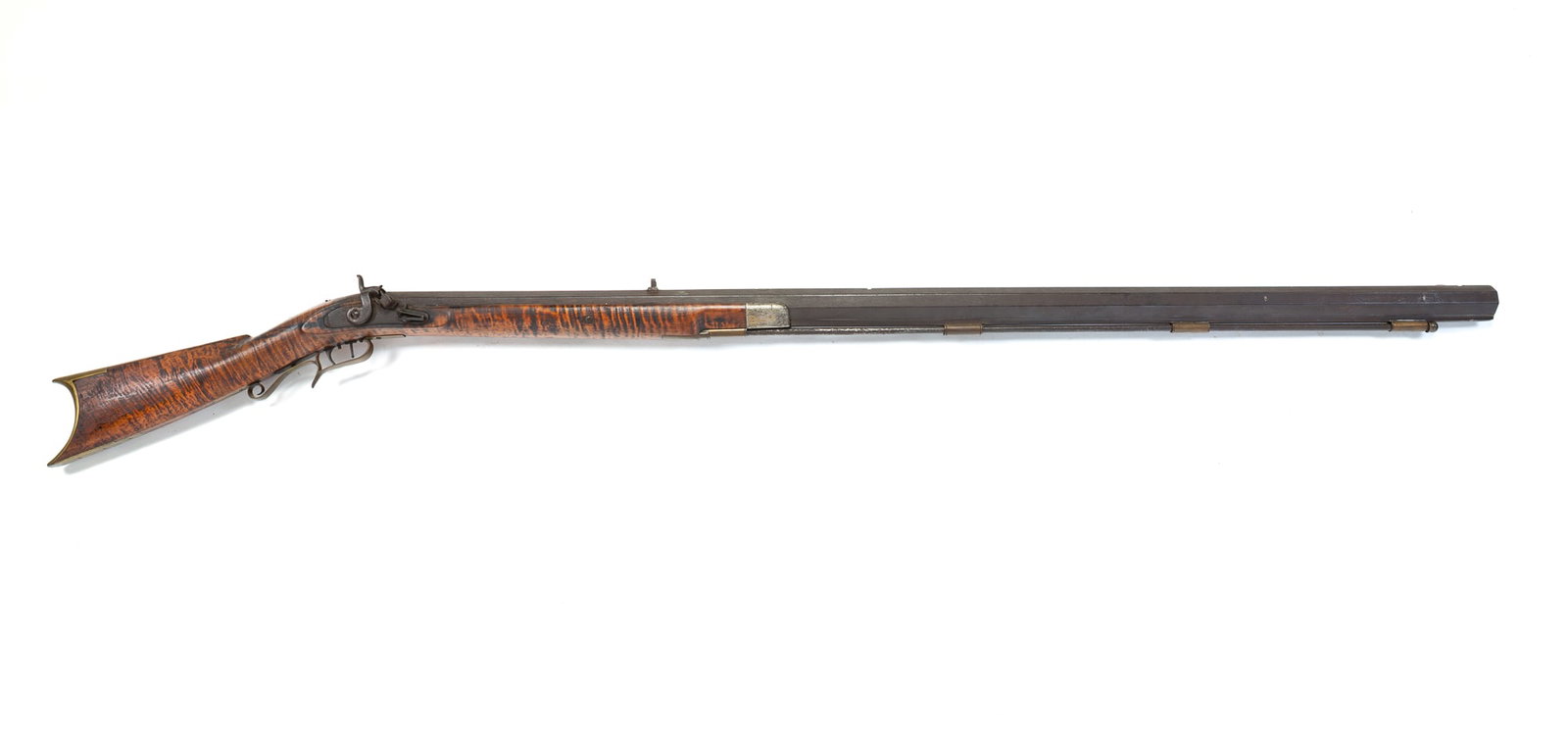 TIGER MAPLE HALF STOCK PERCUSSION TARGET RIFLE.: TIGER MAPLE HALF STOCK PERCUSSION TARGET RIFLE. American, 19th Century. Tiger maple stock with iron hardware, octagonal barrel with precision sights, double triggers, and brass trigger guard and butt