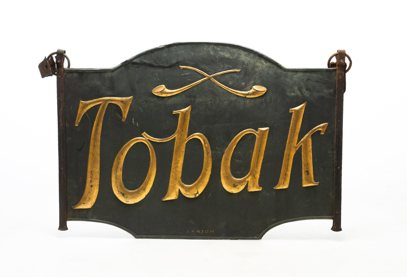 HANGING IRON TWO-SIDED "TOBAK" TRADE SIGN.: HANGING IRON TWO-SIDED "TOBAK" TRADE SIGN. Danish, 19th Century. Shaped signed, raised "Tobak" with crossed pipes in gilt finish, iron strap hangers, and signed "Larson". 28"h. 39.5"w. Provenance: Fro
