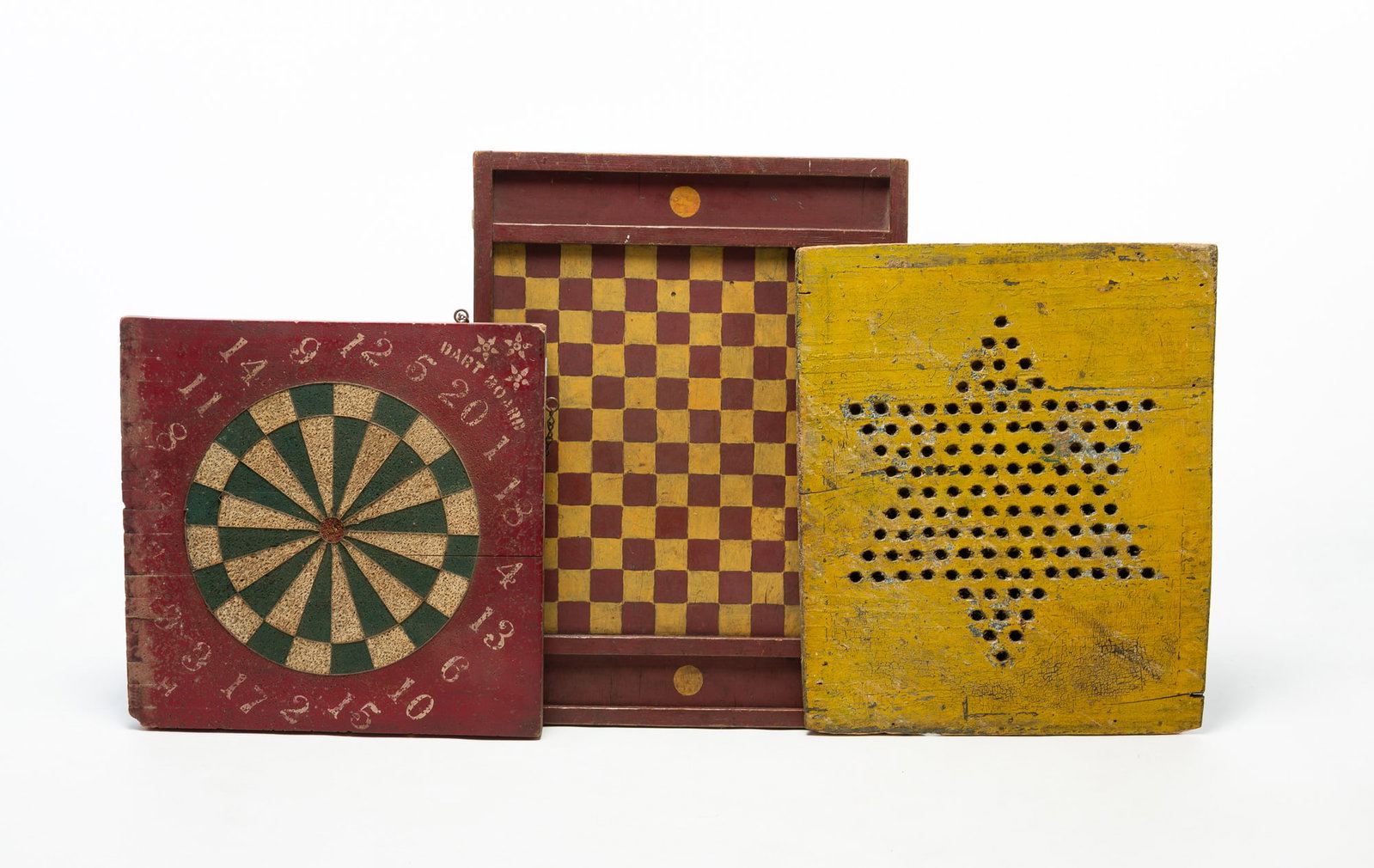 THREE FOLKSY PAINT-DECORATED GAMEBOARDS.: THREE FOLKSY PAINT-DECORATED GAMEBOARDS. American, Late 19th or 20th Century. Wood and cork. Including a red and yellow checkerboard, a yellow Chinese checkers board, and a red, green, and white dart 