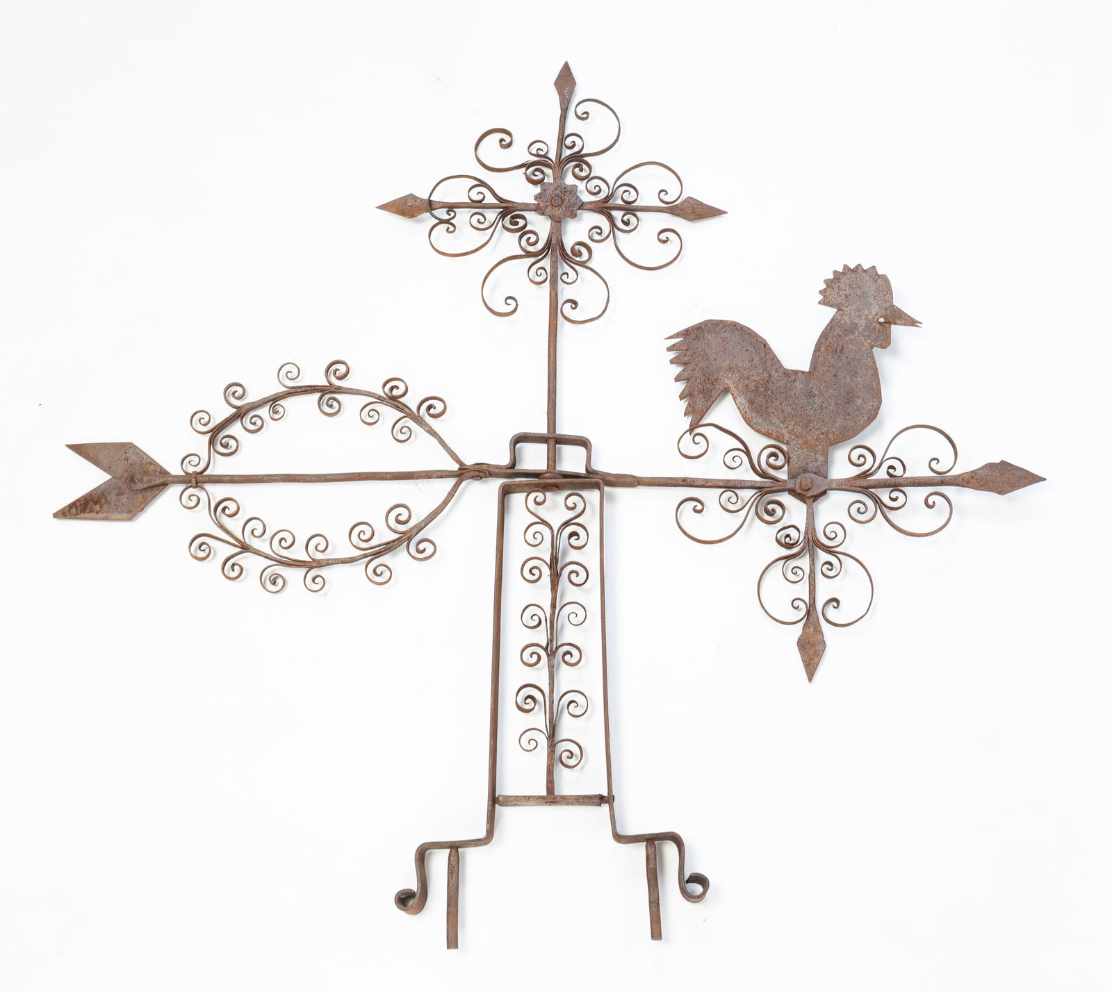FOLK ART SCROLLED IRON WEATHERVANE WITH ROOSTER.: FOLK ART SCROLLED IRON WEATHERVANE WITH ROOSTER. American, 20th Century. Blacksmith made with intricate scroll work and rooster finial on directional. 31"h. 37.25"w. Provenance: The Lifetime Collectio