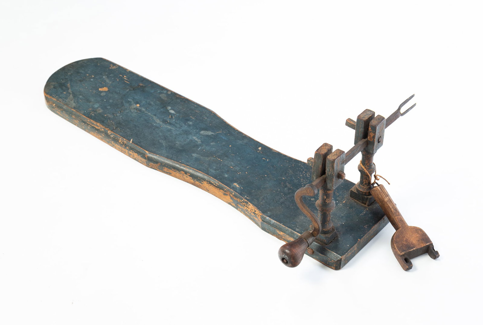 CARVED AND PAINTED HAND-CRANK APPLE PEELER.: CARVED AND PAINTED HAND-CRANK APPLE PEELER. American, 19th Century. Pegged construction. Long shaped base, carved uprights, forged iron fork with wooden handle, and wooden peeler (no blade). Painted b