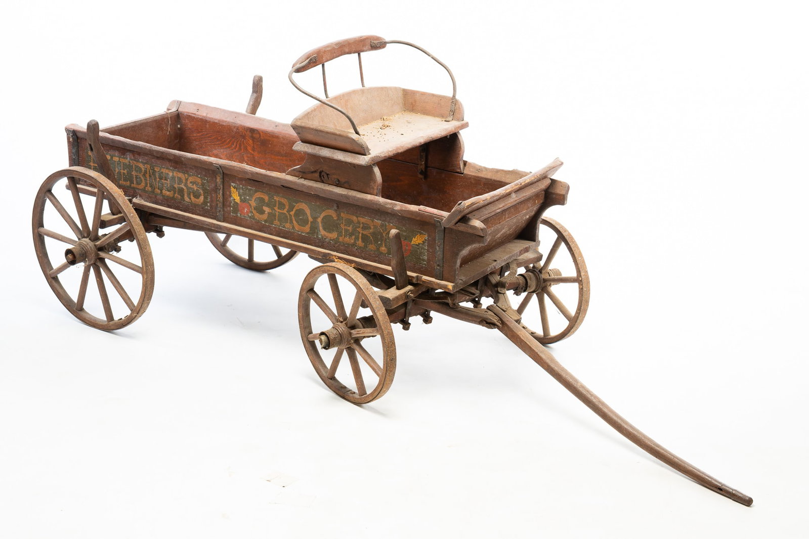 WONDERFUL CHILD'S SIZE BUCK BOARD GOAT WAGON.: WONDERFUL CHILD'S SIZE BUCK BOARD GOAT WAGON. American, 19th Century. Pine. Nicely constructed with wooden spoked wheels and steel tires. Later lettering on sides "Hubner's Grocery". 33"h. 33"w. 54"l.