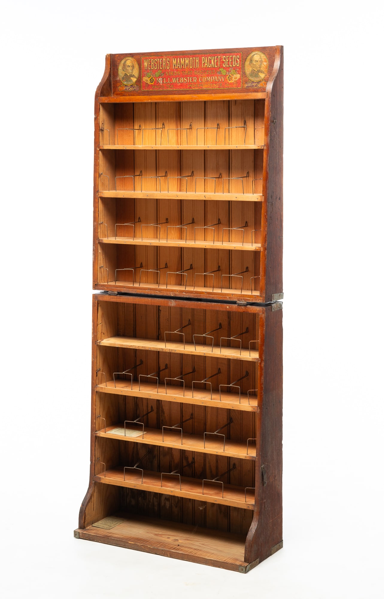 "WEBSTER'S MAMMOTH SEED PACKETS" FOLDING GENERAL STORE DISPLAY CABINET.: "WEBSTER'S MAMMOTH SEED PACKETS" FOLDING GENERAL STORE DISPLAY CABINET. American, Early 20th Century. Oak and pine. Eight graduated shelves with wire seed packet racks and decal label on top crest