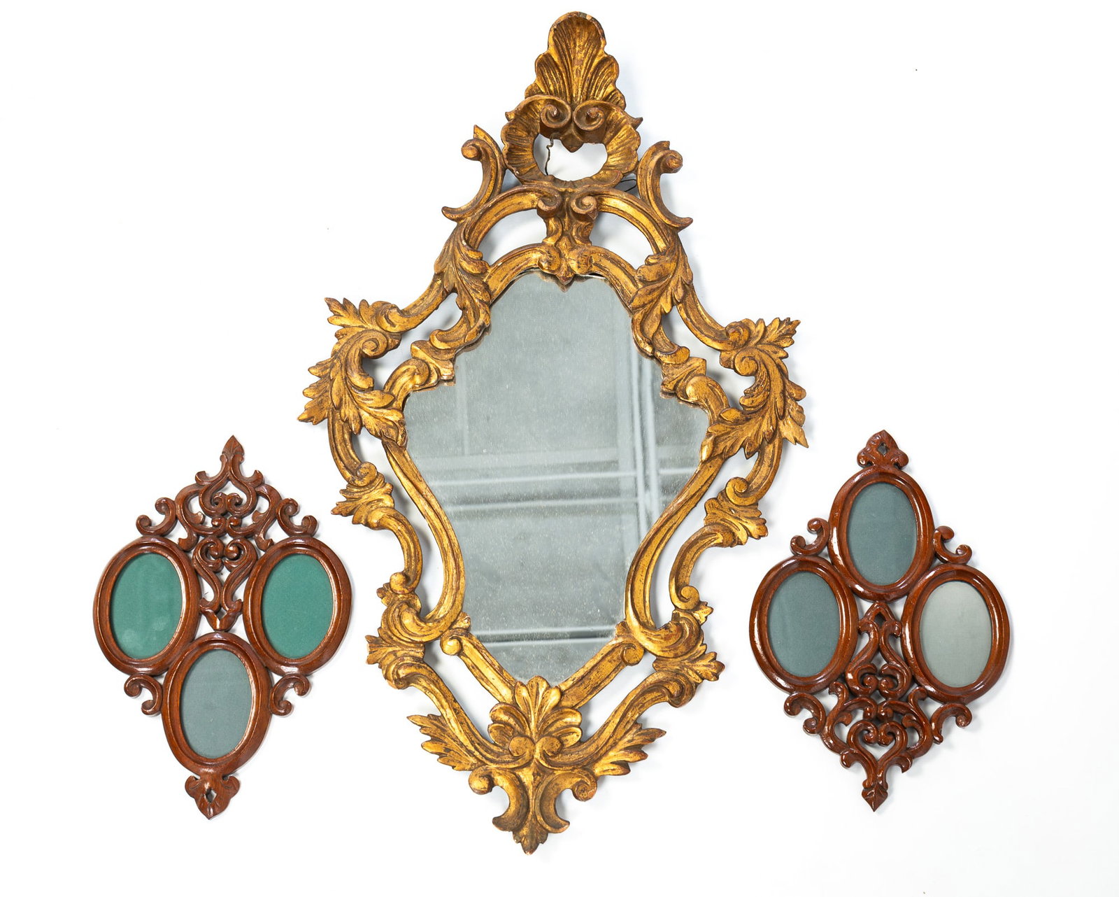 ROCOCO REVIVAL GILTWOOD MIRROR AND A PAIR OF CARVED AND PIERCED WOOD TRIPLE WALL FRAMES.: ROCOCO REVIVAL GILTWOOD MIRROR AND A PAIR OF CARVED AND PIERCED WOOD TRIPLE WALL FRAMES. American, 19th and 20th Centuries. Carved and pierced gilt wood mirror with a shell crest and scrolled sides. 2