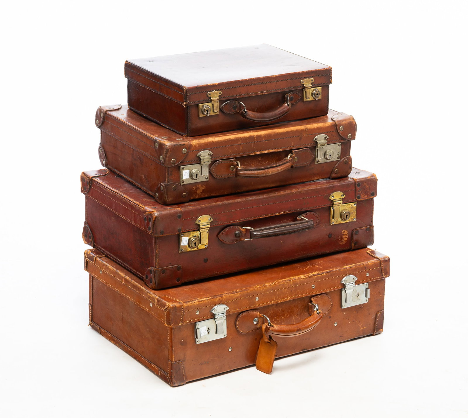 FOUR GRADUATED LEATHER SUITCASES. (1 of 5)