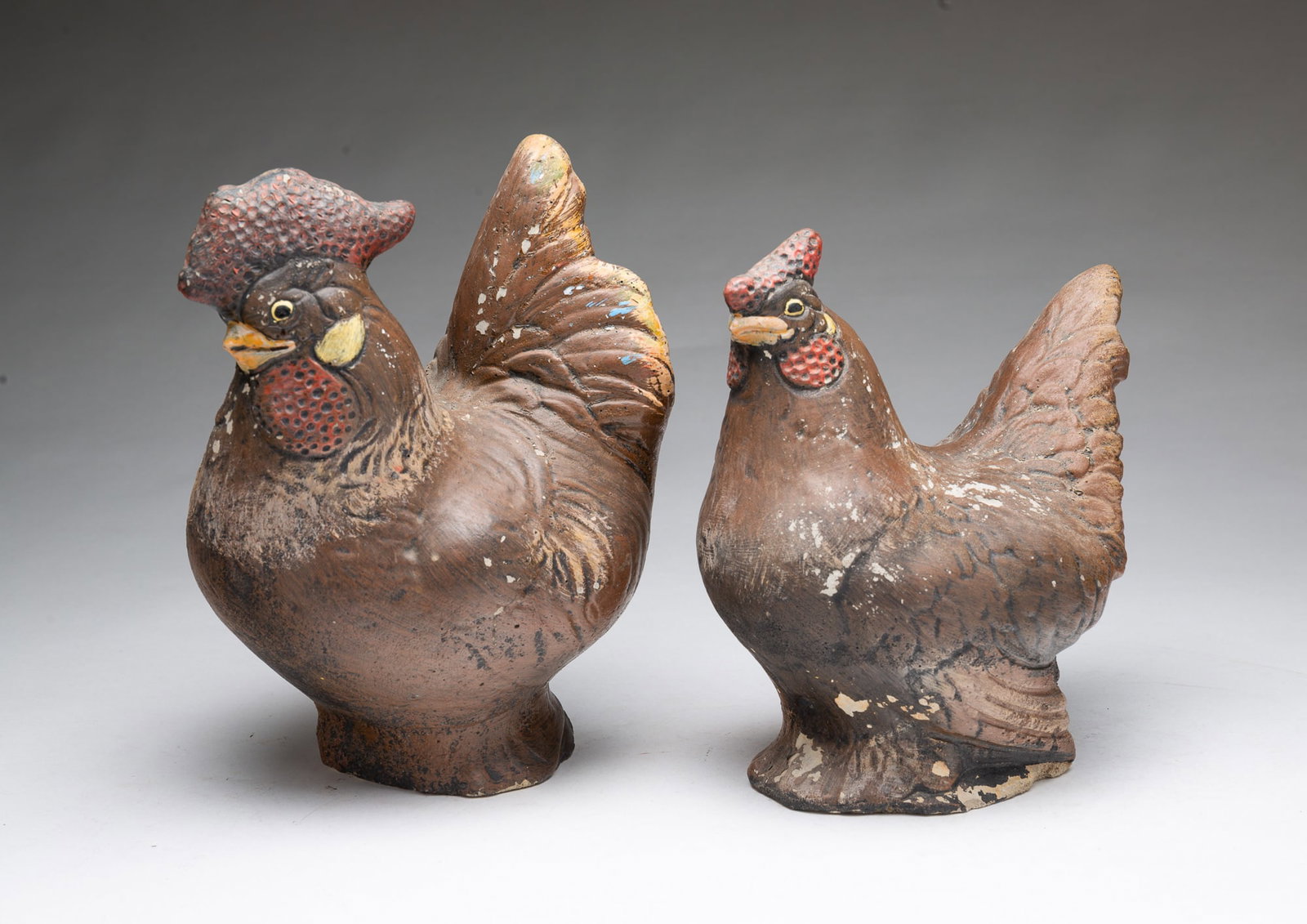 TWO PAINTED AND MOLDED PLASTER ROOSTER AND HEN FIGURES.: TWO PAINTED AND MOLDED PLASTER ROOSTER AND HEN FIGURES. American, 20th Century. Comprising a rooster and hen with molded and painted features. Largest, 10"h. Provenance: The Lifetime Collection of Ric