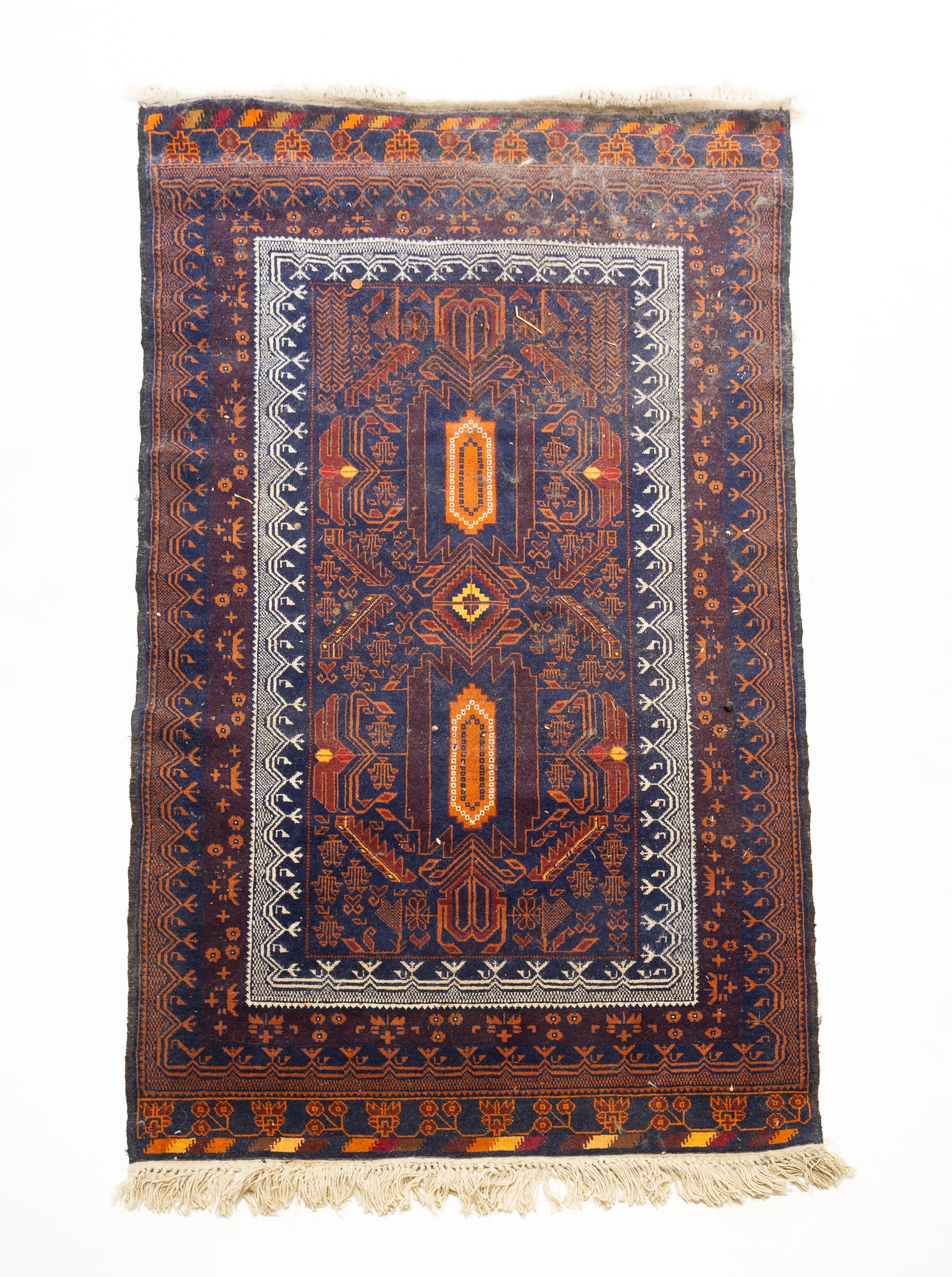 AFGHAN TRIBAL BELUCHI HAND-KNOTTED WOOL AREA RUG.: AFGHAN TRIBAL BELUCHI HAND-KNOTTED WOOL AREA RUG. Afghanistan, 20th Century. Two geometric floral and foliate medallions on a central field within geometric floral and foliate borders, in colors of in