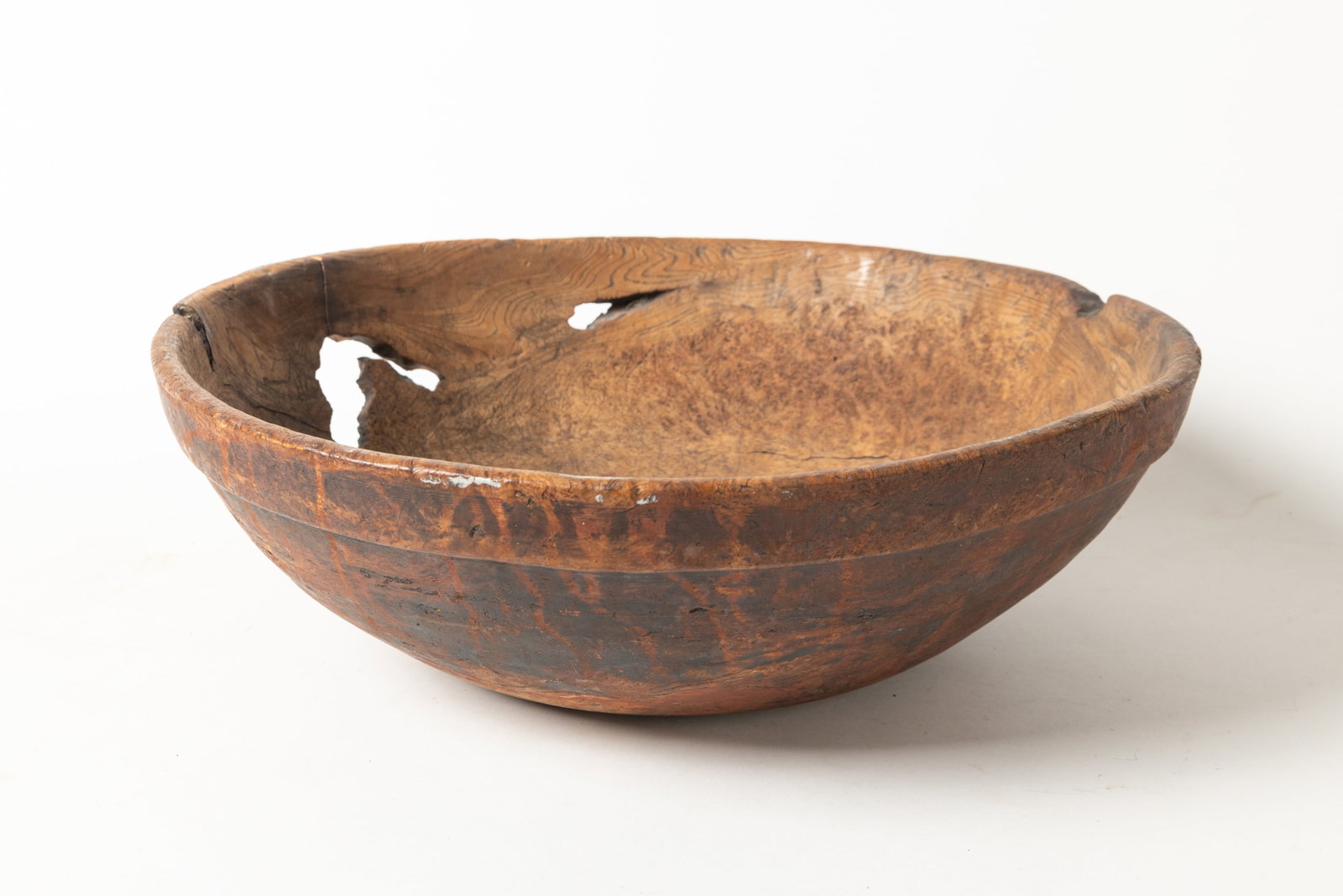 LARGE TURNED BURL BOWL WITH RED PAINT.: LARGE TURNED BURL BOWL WITH RED PAINT. American, 18th Century. Large turned burl bowl with pronounced lip and a knot hole at side. 6.25"h. 19.5"d. Provenance: Nancy Goff (Alliance, Ohio); Lou Hahn (Sl