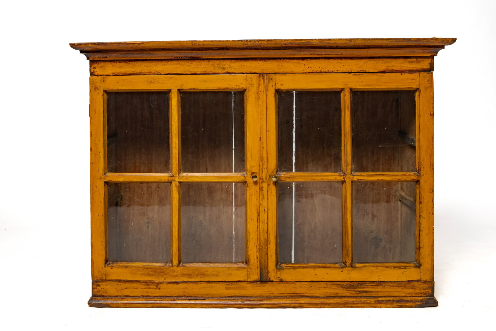 ZOAR HANGING CUPBOARD IN ORIGINAL MUSTARD PAINT: ZOAR HANGING CUPBOARD IN ORIGINAL MUSTARD PAINT American (Ohio), mid- 19th Century. Pine. Dovetailed case, applied cornice and base moldings, and two four-pane glass doors. 31"h. 44"w. 13.5"d.