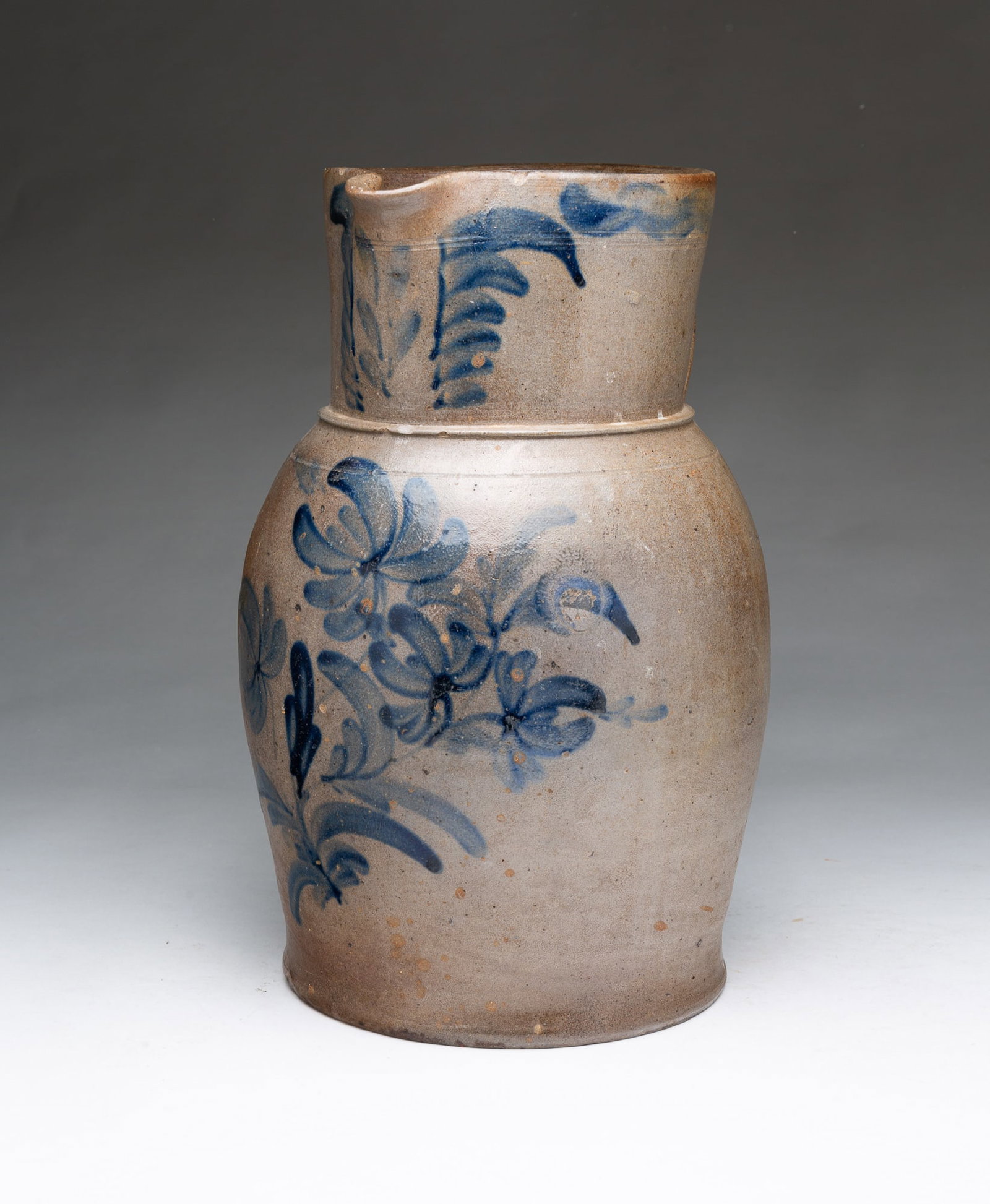 LARGE PENNSYLVANIA FREEHAND COBALT-DECORATED TWO-GALLON STONEWARE PITCHER.: LARGE PENNSYLVANIA FREEHAND COBALT-DECORATED TWO-GALLON STONEWARE PITCHER. American, 19th Century. Pinched spout, tooled collard, and applied strap handle, the front of the spout and body decorated