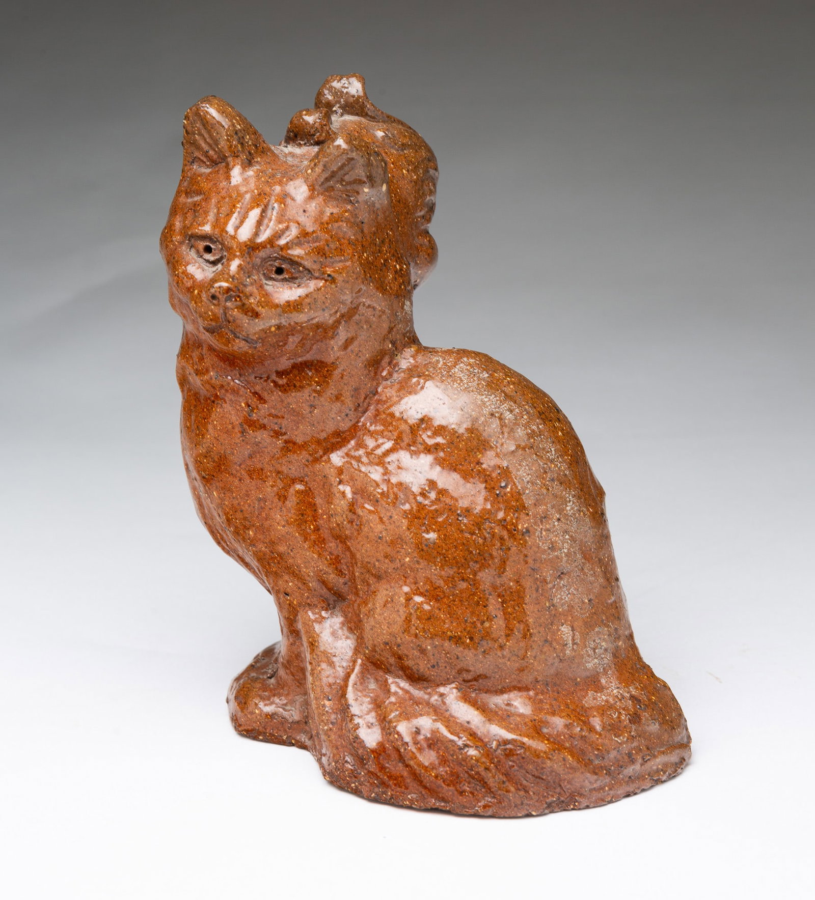OHIO SEWER TILE DOUBLE-HEADED CAT WITH DUCK.: OHIO SEWER TILE DOUBLE-HEADED CAT WITH DUCK. American, 19th Century. Seated cat with molded and incised decoration and pierced eyes, having a duckling face protruding from the back of its head, in an