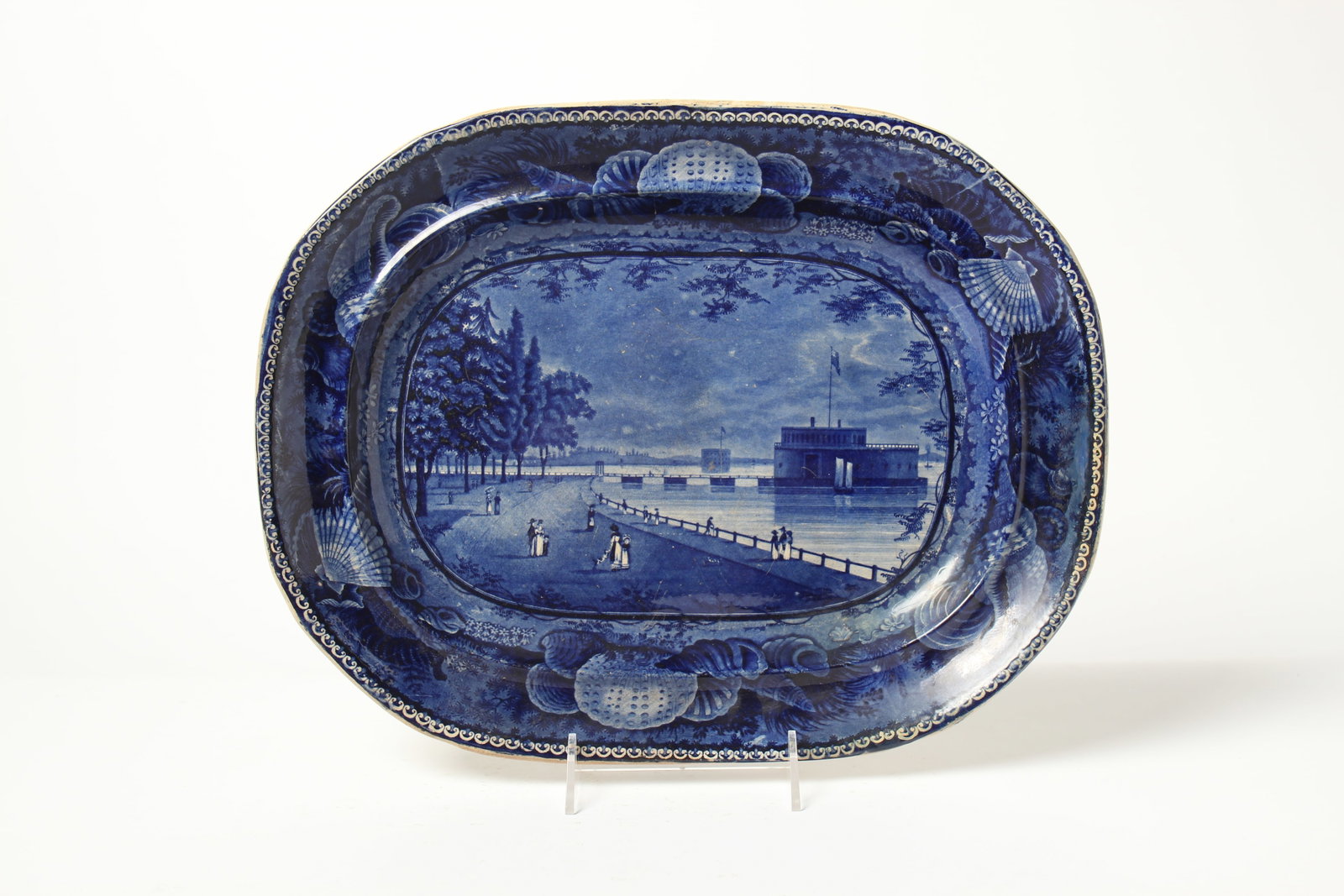 ENOCH WOOD AND SONS HISTORICAL BLUE PLATTER "LAKE GEORGE, STATE OF NEW YORK" PLATTER.: ENOCH WOOD AND SONS HISTORICAL BLUE PLATTER "LAKE GEORGE, STATE OF NEW YORK" PLATTER. England, mid- 19th Century. Shell border, center lake scene and cobalt eagle transfer mark on reverse, 18.25"w.