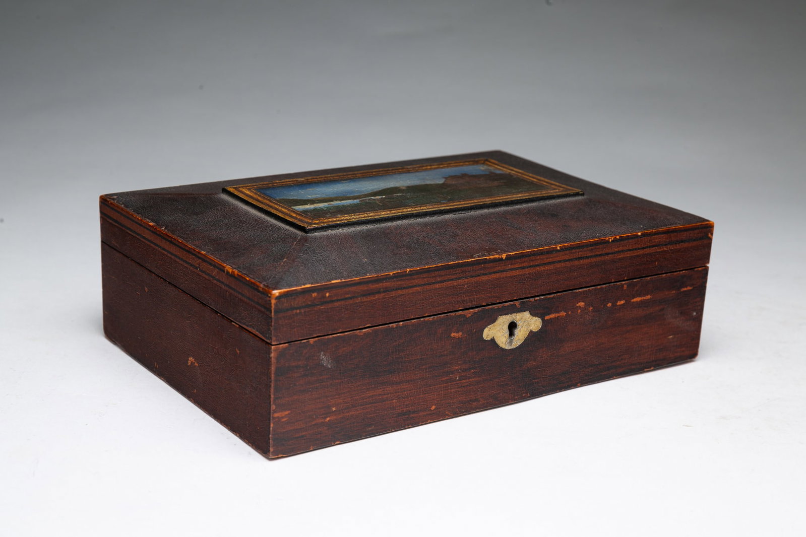 GRAIN-PAINTED BOX WITH WASHINGTON'S HEADQUARTERS LANDSCAPE PAINTING.: GRAIN-PAINTED BOX WITH WASHINGTON'S HEADQUARTERS LANDSCAPE PAINTING. American, 19th Century. Grain-painted box with hinged lid, framed painting showing Washington's headquarters at Newburg, New York, 