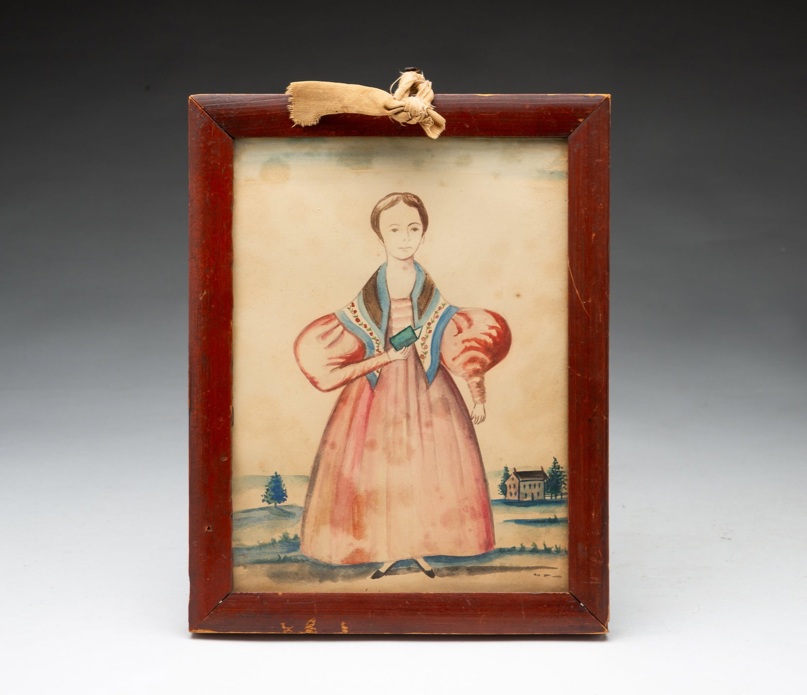 WATERCOLOR FULL-LENGTH PORTRAIT OF A YOUNG WOMAN.: WATERCOLOR FULL-LENGTH PORTRAIT OF A YOUNG WOMAN. American, 19th Century. She wears her brown hair short with a polychrome floral scarf over a pink dress with puffy sleeves and black shoes, holding a 