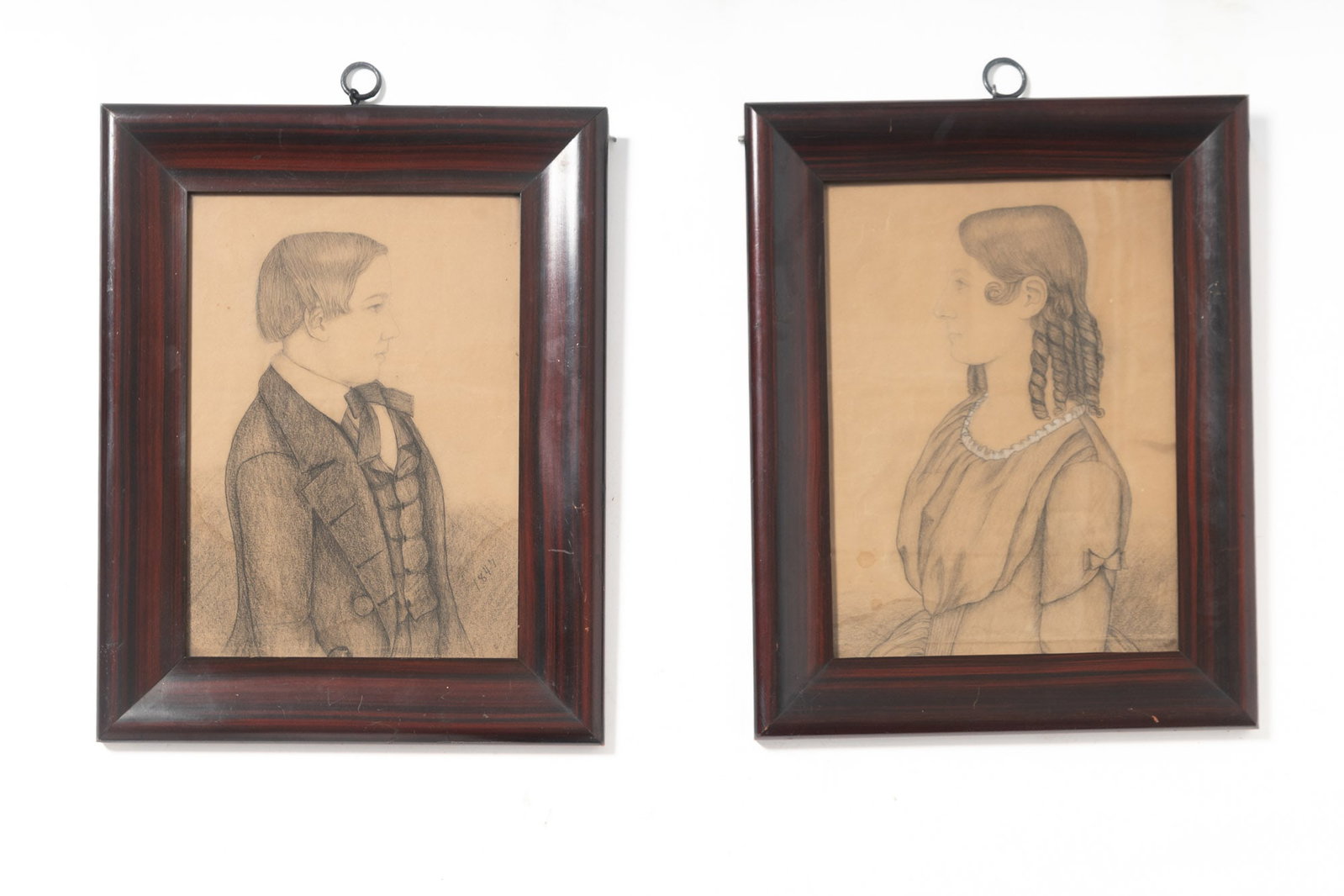 PAIR OF MIXED MEDIA BROTHER AND SISTER PORTRAITS DATED 1847.: PAIR OF MIXED MEDIA BROTHER AND SISTER PORTRAITS DATED 1847. American (Valparaiso, Indiana), mid- 19th Century. Pencil and charcoal on paper. A boy standing wearing a coat, vest, and bow tie with stra