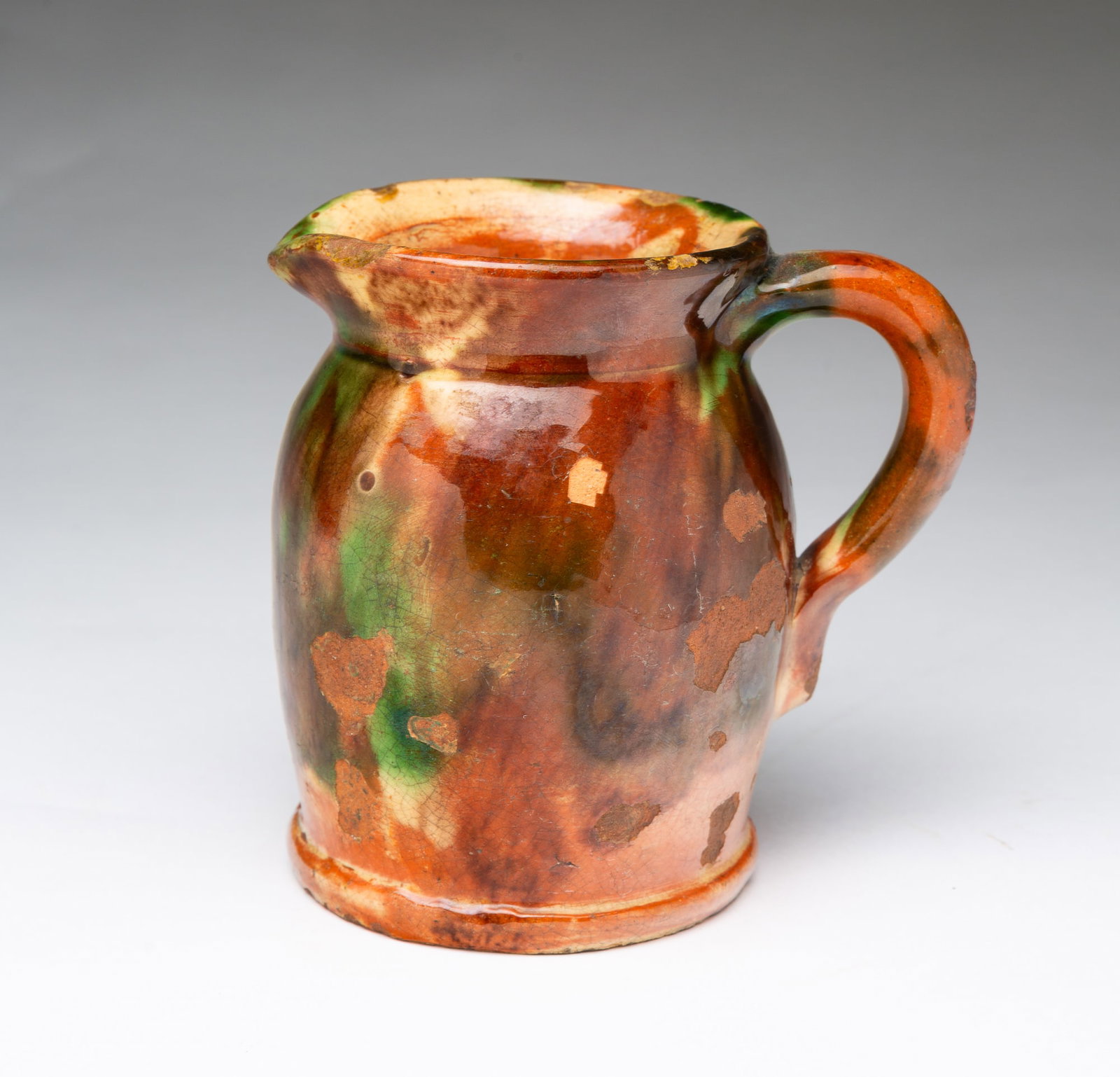 ATTRIBUTED TO SHENANDOAH VALLEY, VIRGINIA POLYCHROME-GLAZED REDWARE CREAM PITCHER. (1 of 4)