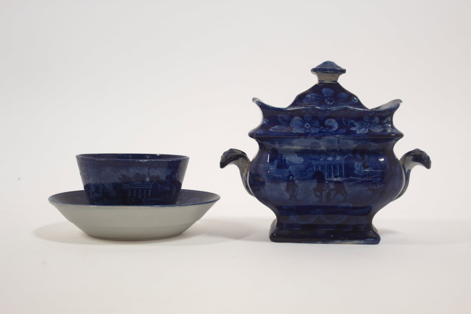 TWO MOUNT VERNON HISTORICAL BLUE ITEMS.: TWO MOUNT VERNON HISTORICAL BLUE ITEMS. England, mid- 19th Century. Possibly Enoch Wood and Sons, with floral borders. Lidded sugar bowl, rectangular with bulbous body. 5.5"h. And a handless cup and s