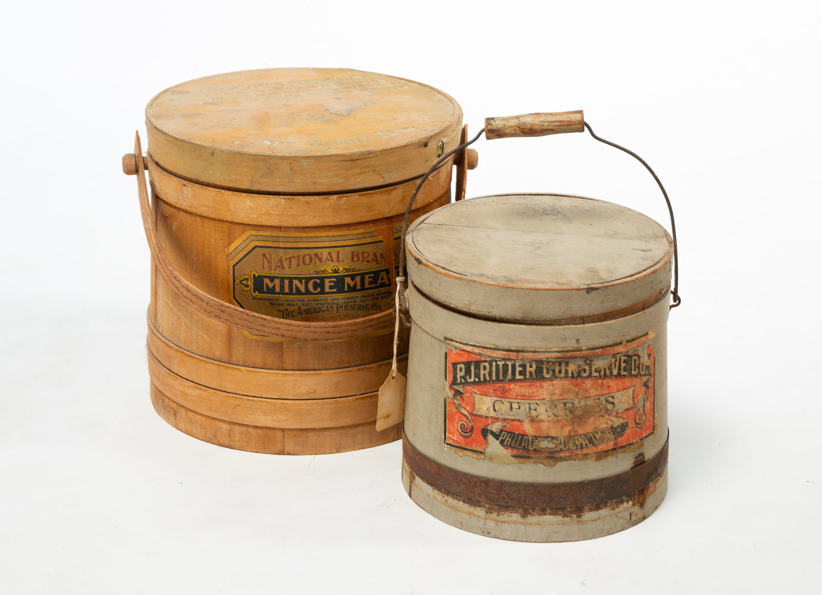 TWO PHILADELPHIA, PENNSYLVANIA FIRKINS WITH PAPER LABELS.: TWO PHILADELPHIA, PENNSYLVANIA FIRKINS WITH PAPER LABELS. American, late 19th Century. Both are stave-constructed. The larger with wood bale handle, labeled "National Brand Mince Meat", 10"h., and the