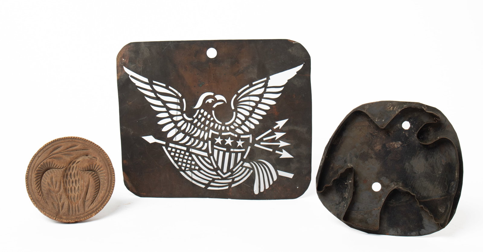 GROUP OF PATRIOTIC ITEMS WITH EAGLES, INCLUDING A COOKIE CUTTER, BUTTER PRINT, AND STENCIL.: GROUP OF PATRIOTIC ITEMS WITH EAGLES, INCLUDING A COOKIE CUTTER, BUTTER PRINT, AND STENCIL. American, 19th Century. The butter print with deep and finely carved eagle and sawtooth border, 4.25"d. Larg