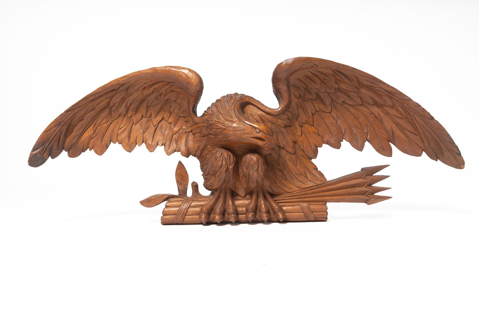 LARGE BELLAMY SCHOOL CARVED EAGLE.: LARGE BELLAMY SCHOOL CARVED EAGLE. American, late 19th or early 20th Century. Pine. Well carved war eagle with arrows and a bundled group of sticks clutched in his talons. 19"h. 50.25"w. Catalogers no