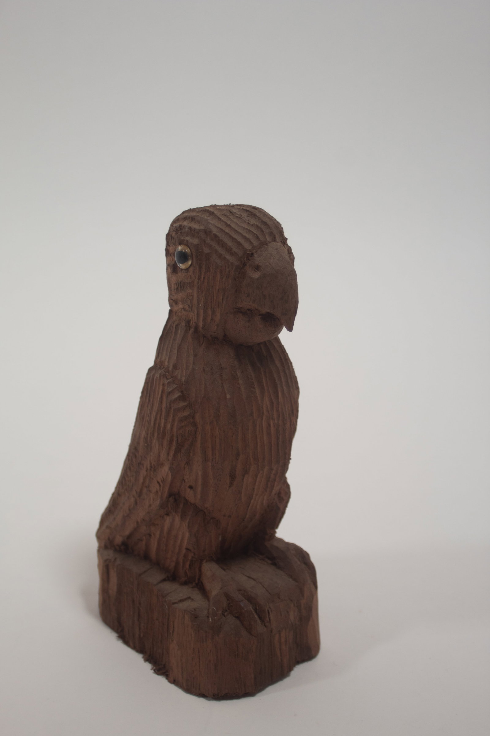 ERNEST "POPEYE" REED (OHIO, 1919-1985) FOLK ART CARVED WOOD DIMINUTIVE EAGLE SCULPTURE.: ERNEST "POPEYE" REED (OHIO, 1919-1985) FOLK ART CARVED WOOD DIMINUTIVE EAGLE SCULPTURE. American, 20th Century. An eagle standing with a textured body, glass eyes, and on an oval plinth. 7.5"h. 3"w.
