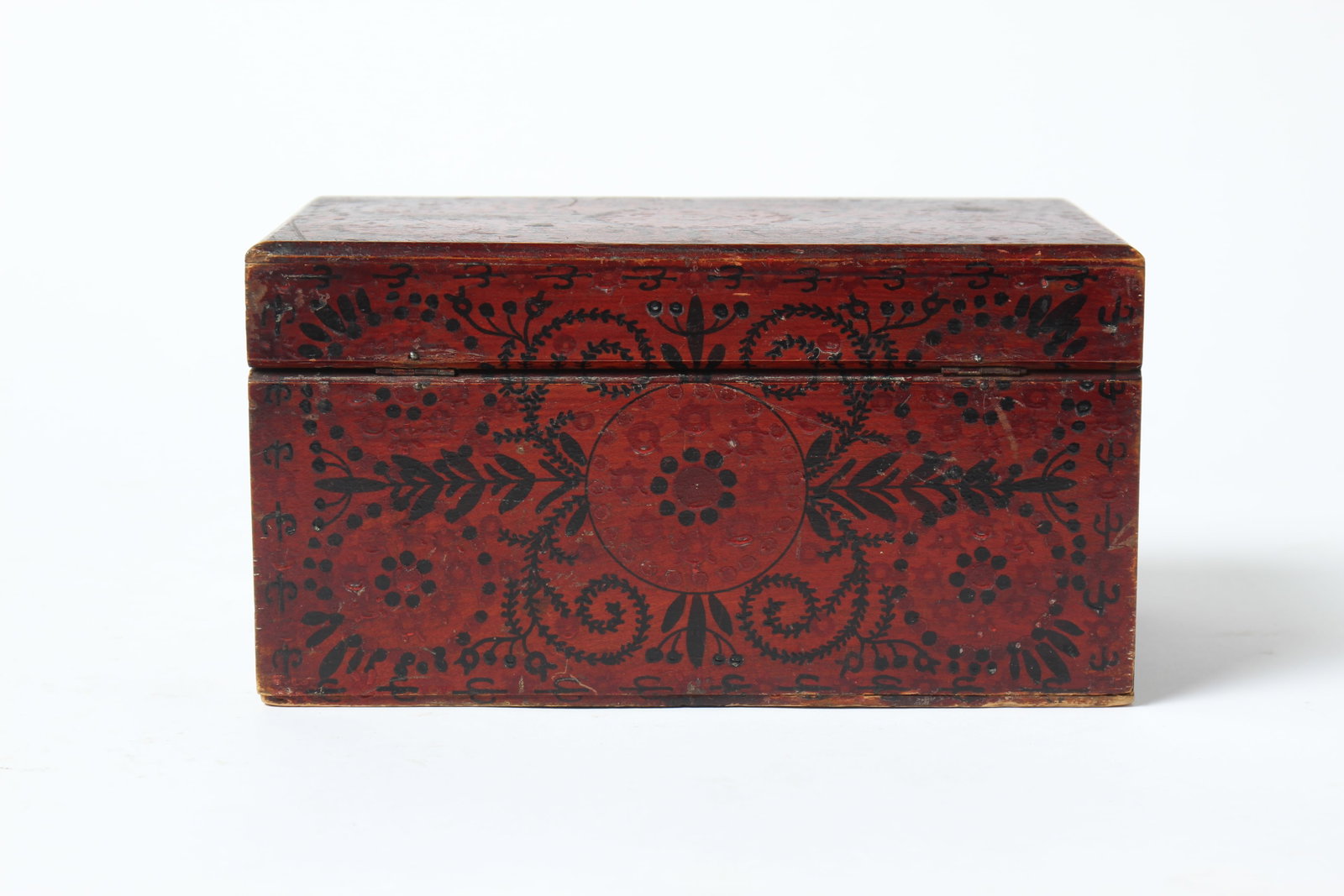 NEW ENGLAND DECORATED BOX.: NEW ENGLAND DECORATED BOX. American, 19th Century. Basswood. A rectangular box with a divided interior, dark red exterior with black decoration of circles, flowers, and vines. 5.25"h. 10"w.