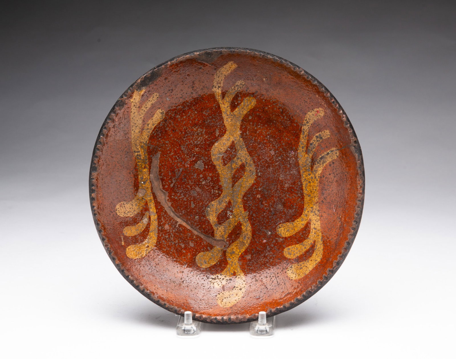 SLIP-DECORATED REDWARE PLATE. (1 of 3)