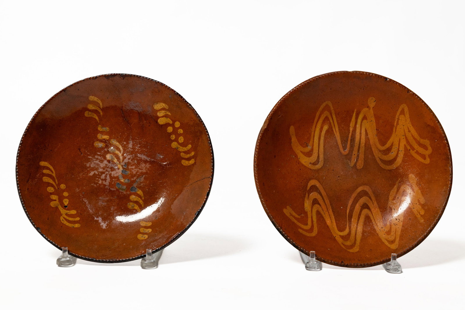 TWO SLIP-DECORATED REDWARE PLATES. (1 of 2)