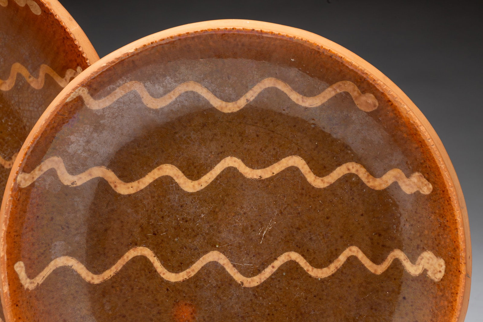 TWO SLIP-DECORATED REDWARE PLATES. - 2
