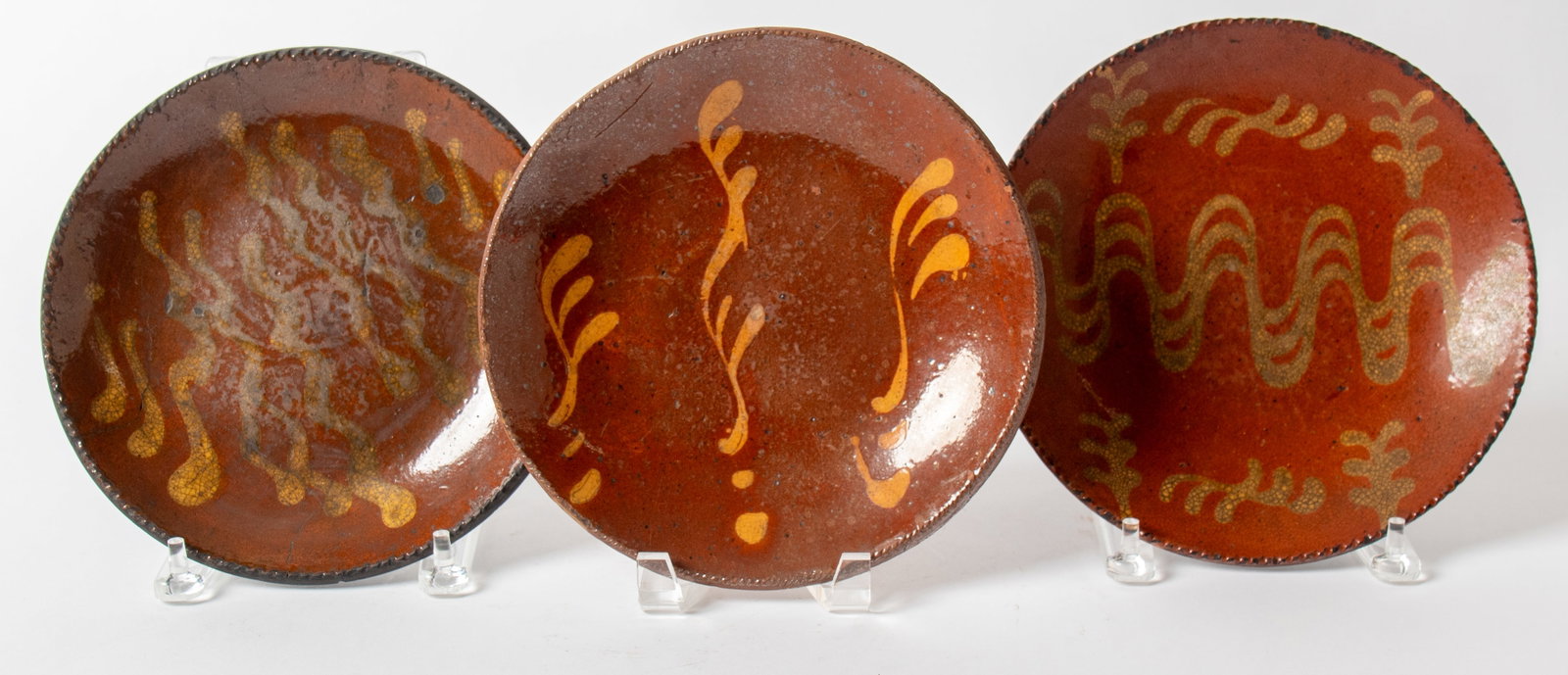 THREE SLIP-DECORATED REDWARE PLATES. (1 of 5)