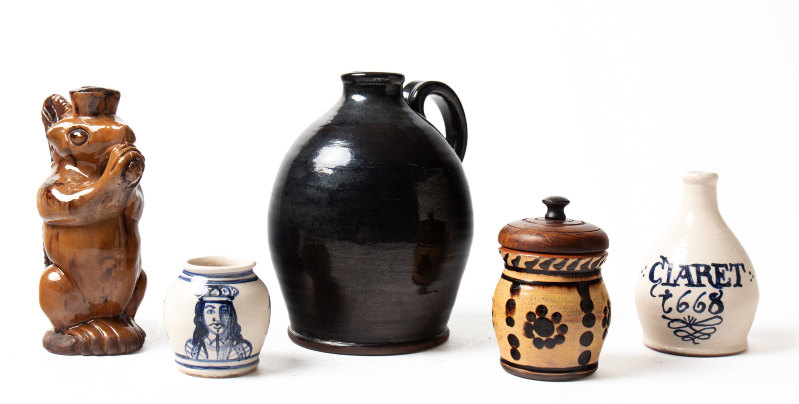FIVE TURTLE CREEK REDWARE ITEMS.: FIVE TURTLE CREEK REDWARE ITEMS. American, contemporary. An ovoid jug with applied handle and manganese glaze, 7.75"h., squirrel-shaped bottle, Rockingham glaze, 7.25"h., ovoid jug with an applied han