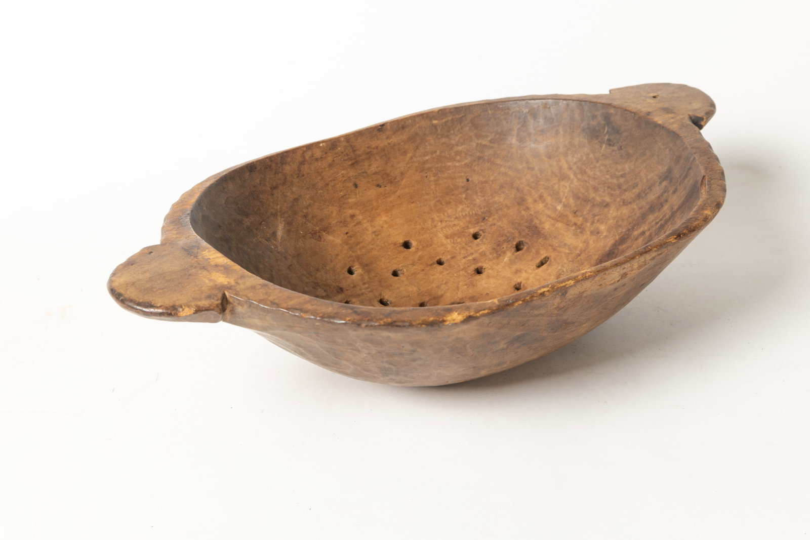UNUSUAL TREEN COLANDER.: UNUSUAL TREEN COLANDER. American (New Jersey), Late 18th Century. Carved oval form with large tab handles, and pierced bottom. 4.5"h. 18"w. Provenance: Nancy Goff (Alliance, Ohio).