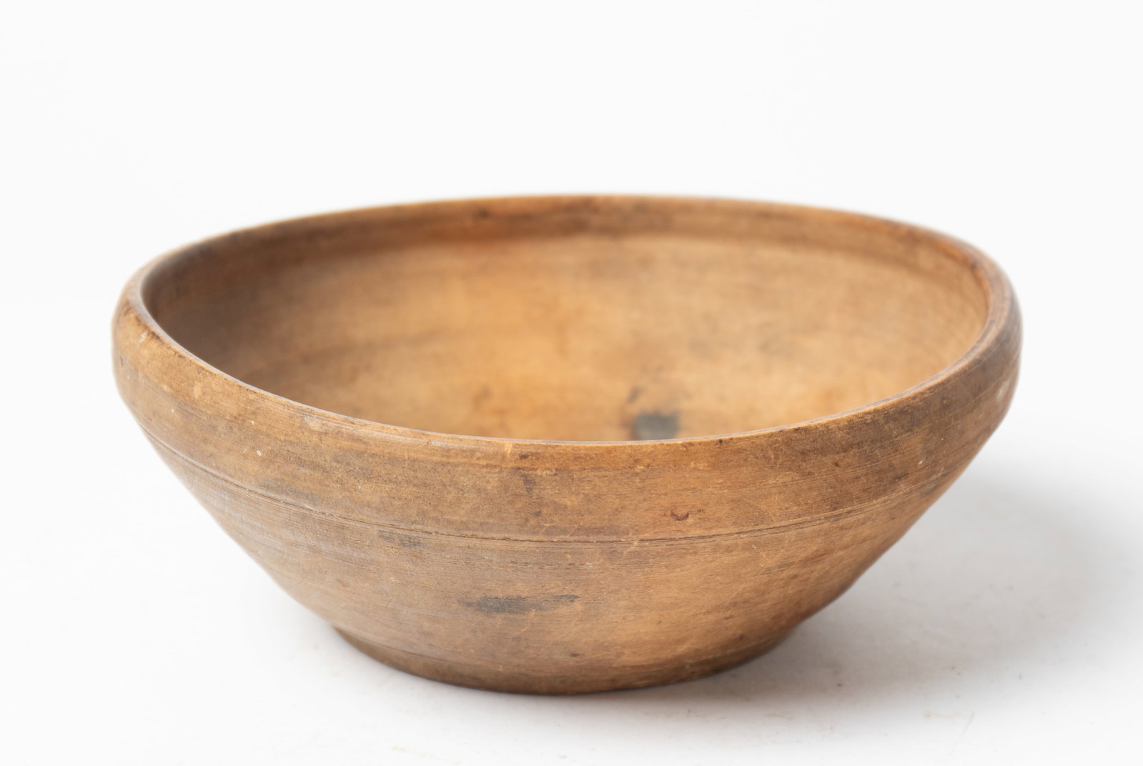 EARLY TREENWARE TURNED BOWL.: EARLY TREENWARE TURNED BOWL. American (New England), late 18th Century. Turned bowl with pronounced foot, slightly rolled rim, and almost oval. In natural finish. Provenance: Nancy Goff (Alliance,