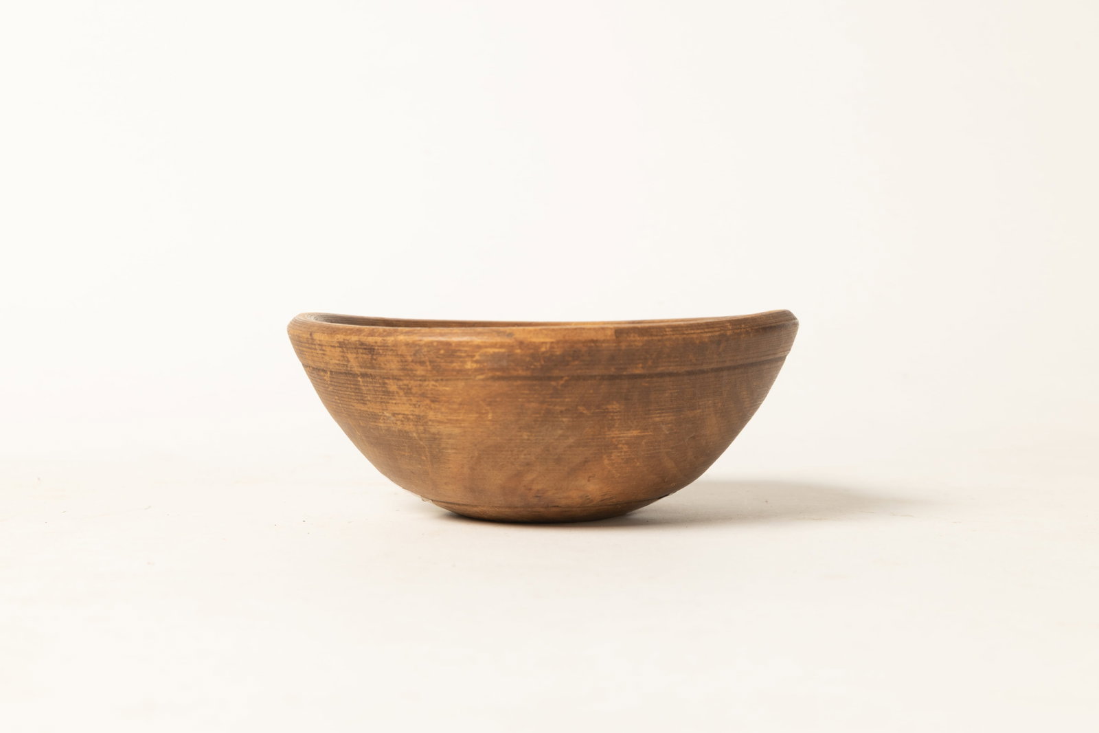 TURNED WOODEN BOWL, MADE INTO SIEVE.: TURNED WOODEN BOWL, MADE INTO SIEVE. American, 19th Century. Turned wooden bowl with banding, deep incised band at rim, and open bottom. 2.5"h. 6.75"d. Provenance: Nancy Goff (Alliance, Ohio); Newsom