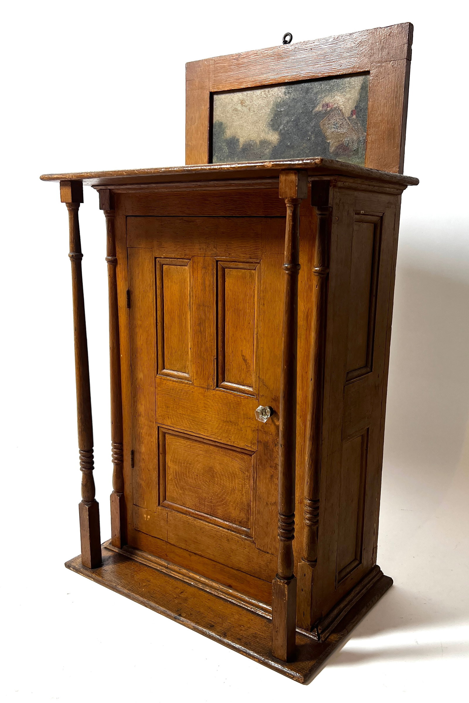 LANCASTER COUNTY, PENNSYLVANIA GRAIN AND PAINT-DECORATED HANGING CUPBOARD.: LANCASTER COUNTY, PENNSYLVANIA GRAIN AND PAINT-DECORATED HANGING CUPBOARD. American, 19th Century. Mixed woods. The grain-painted case having a rectangular top backed by a raised, landscape-painted