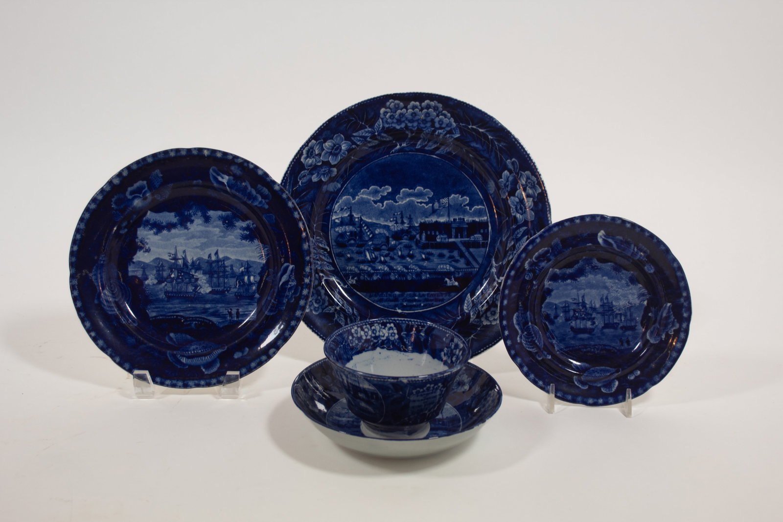 FOUR HISTORICAL BLUE ITEMS WITH AMERICAN SCENES.: FOUR HISTORICAL BLUE ITEMS WITH AMERICAN SCENES. England, mid- 19th Century. Two are Clews "Landing Of. Gen'l. Lafayette At Castle Garden, New York August 1824" an oversized-handled cup and saucer and