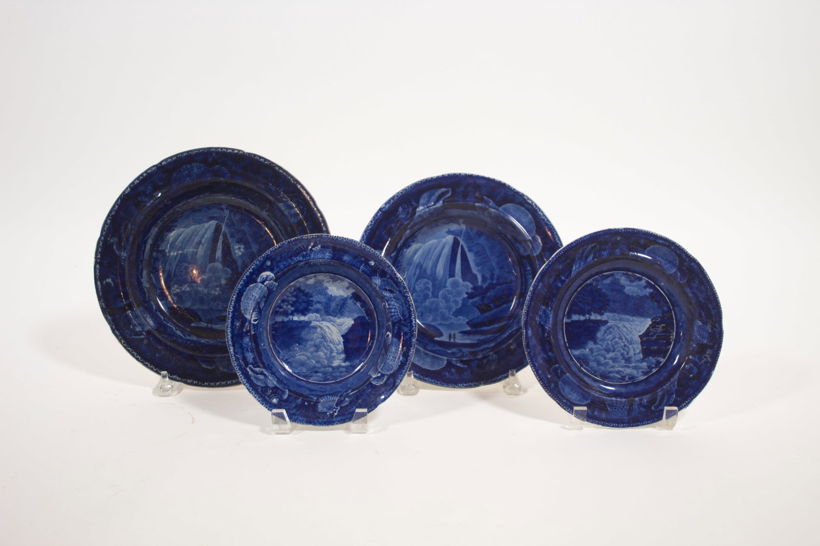 FOUR HISTORICAL BLUE PLATES WITH AMERICAN WATERFALL SCENES.: FOUR HISTORICAL BLUE PLATES WITH AMERICAN WATERFALL SCENES. England, mid- 19th Century. Two are "View of Trenton Falls" with shell borders by Enoch Wood & Son. 7.25"d. and 7.5"d. And two "Table Rock