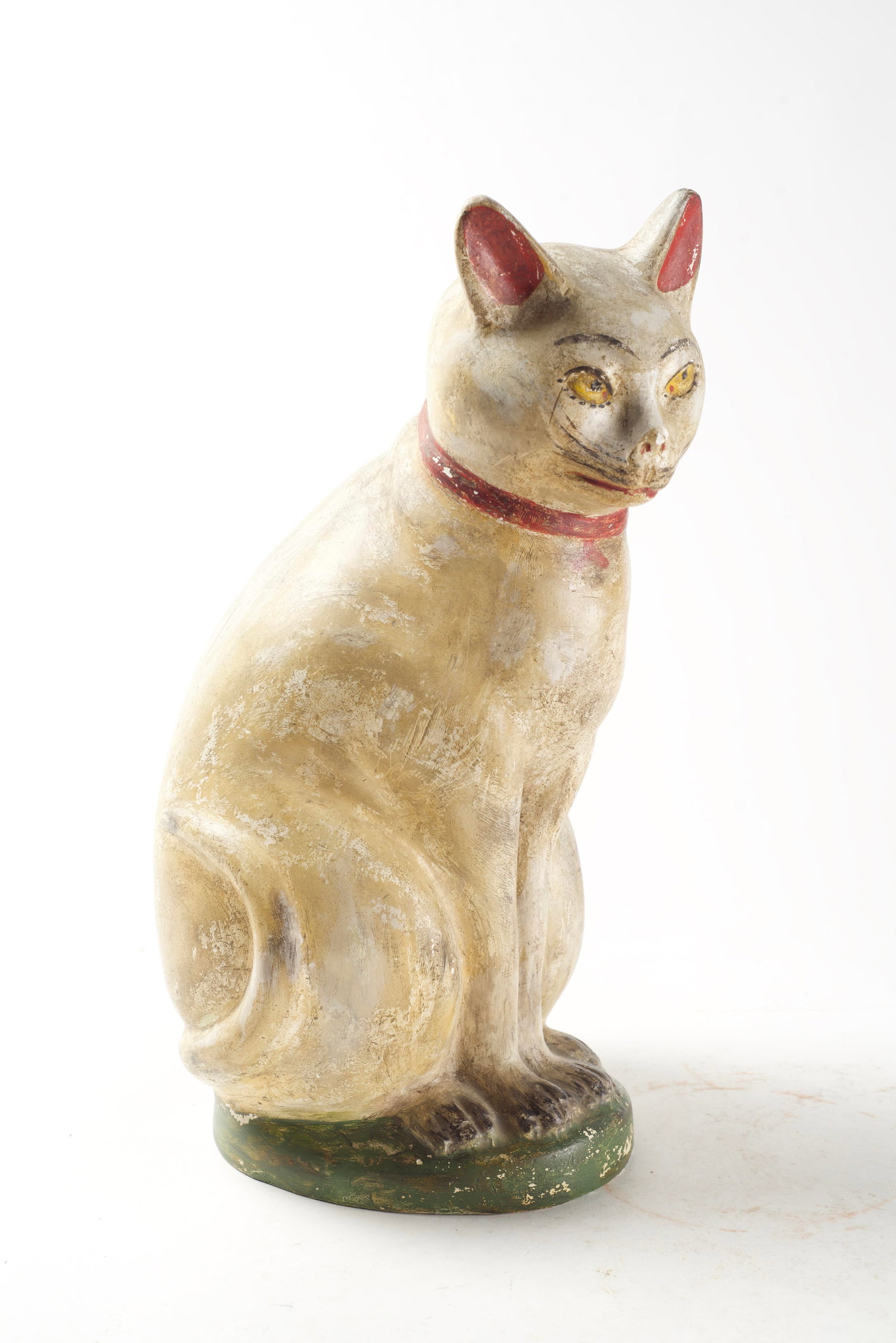 LARGE SEATED CHALKWARE CAT.: LARGE SEATED CHALKWARE CAT. American, 19th Century. Full-bodied, seated cat with black paint decoration, yellow eyes, and a red collar with bell. 15.75"h. 8"d. Sold at Pook & Pook (Downingtown, Pennsy